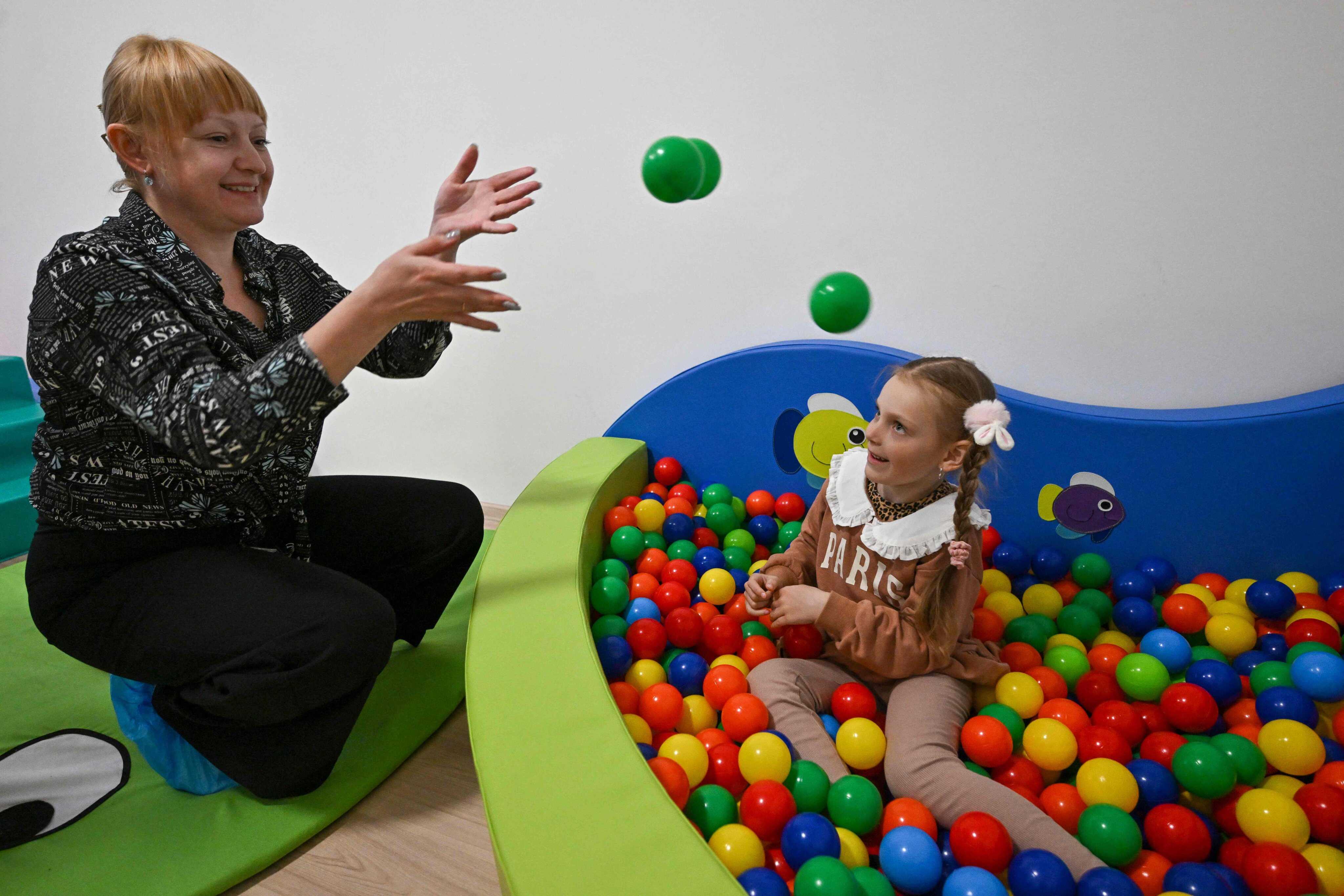 A picture taken on April 14, 2023 shows Ukrainian refugee speech therapist and founder of the AKSEN (Assistance for Kids with Special Educational Needs) project Olena Andriichuk (L) with a Ukrainian refugee child patient in Budapest, Hungary. Photo: AFP