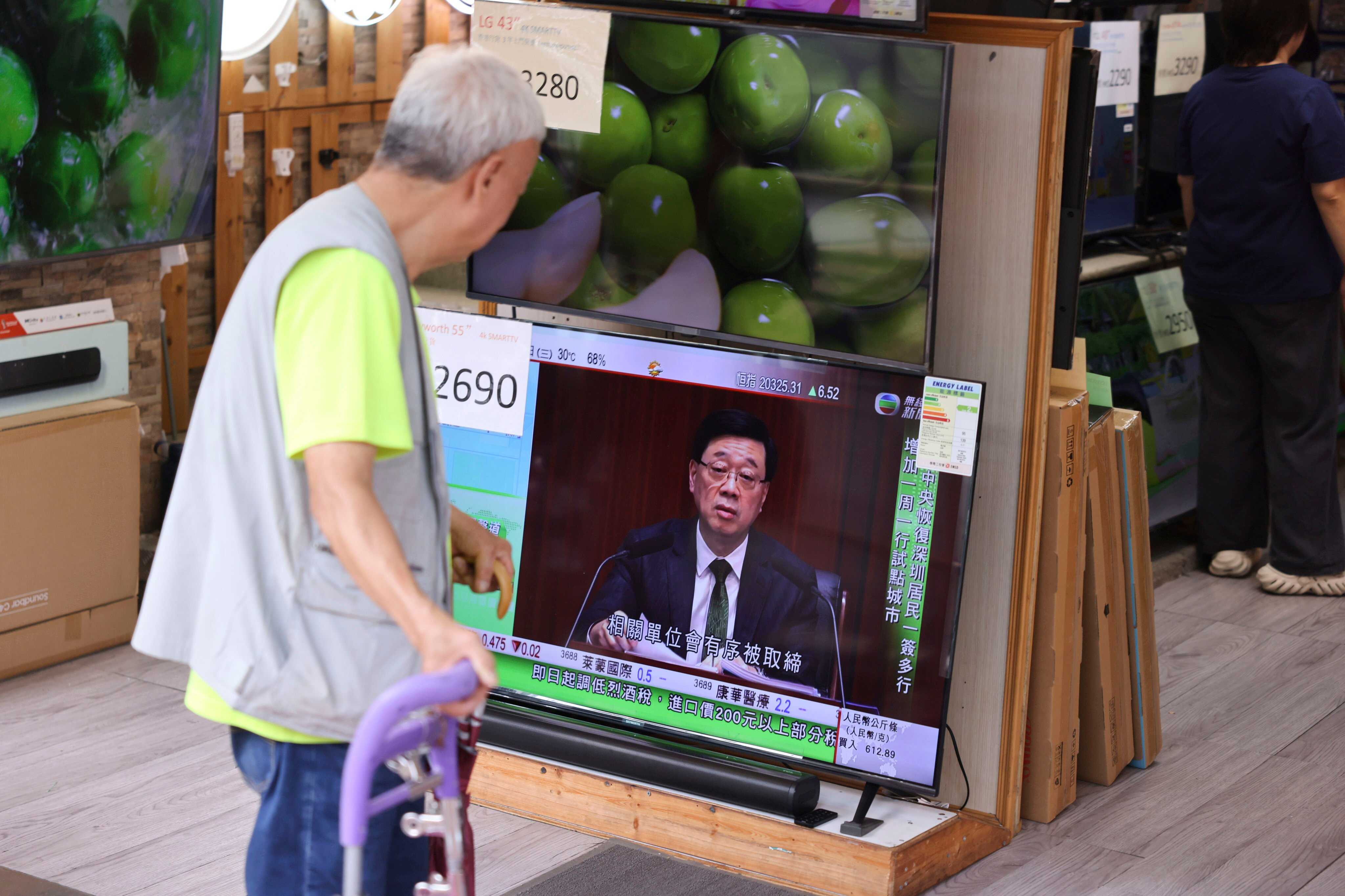 A less privileged elderly person watches a live broadcast of Chief Executive John Lee Ka-chiu on TV in Sham Shui Po. Photo: Nora Tam