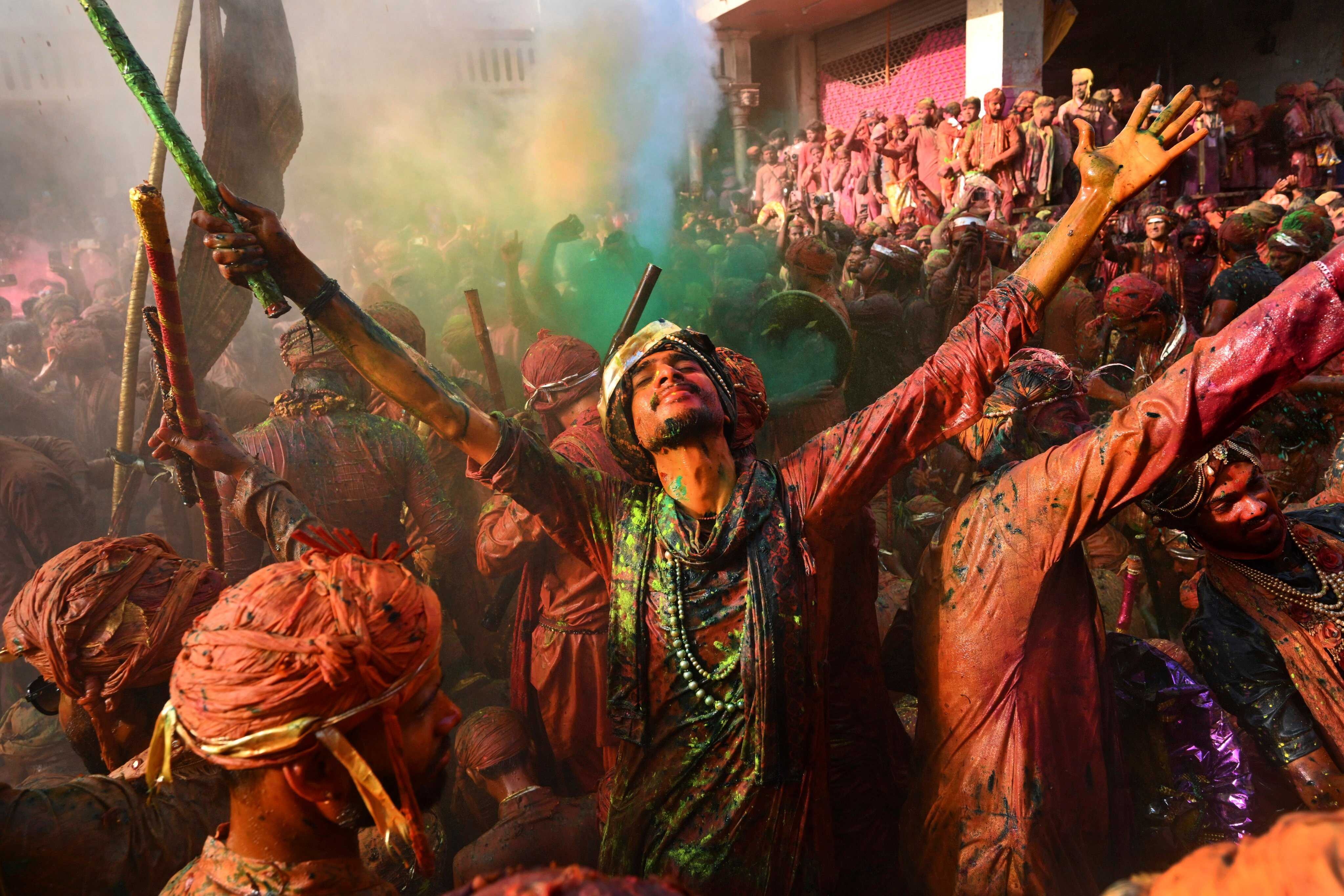 Villagers from Barsana and Nandgaon, smeared with colours, sing and dance as they participate in Lathmar Holi at Nandagram temple in Nandgoan village, 115 kilometres (70 miles) south of New Delhi, India. Photo: AP