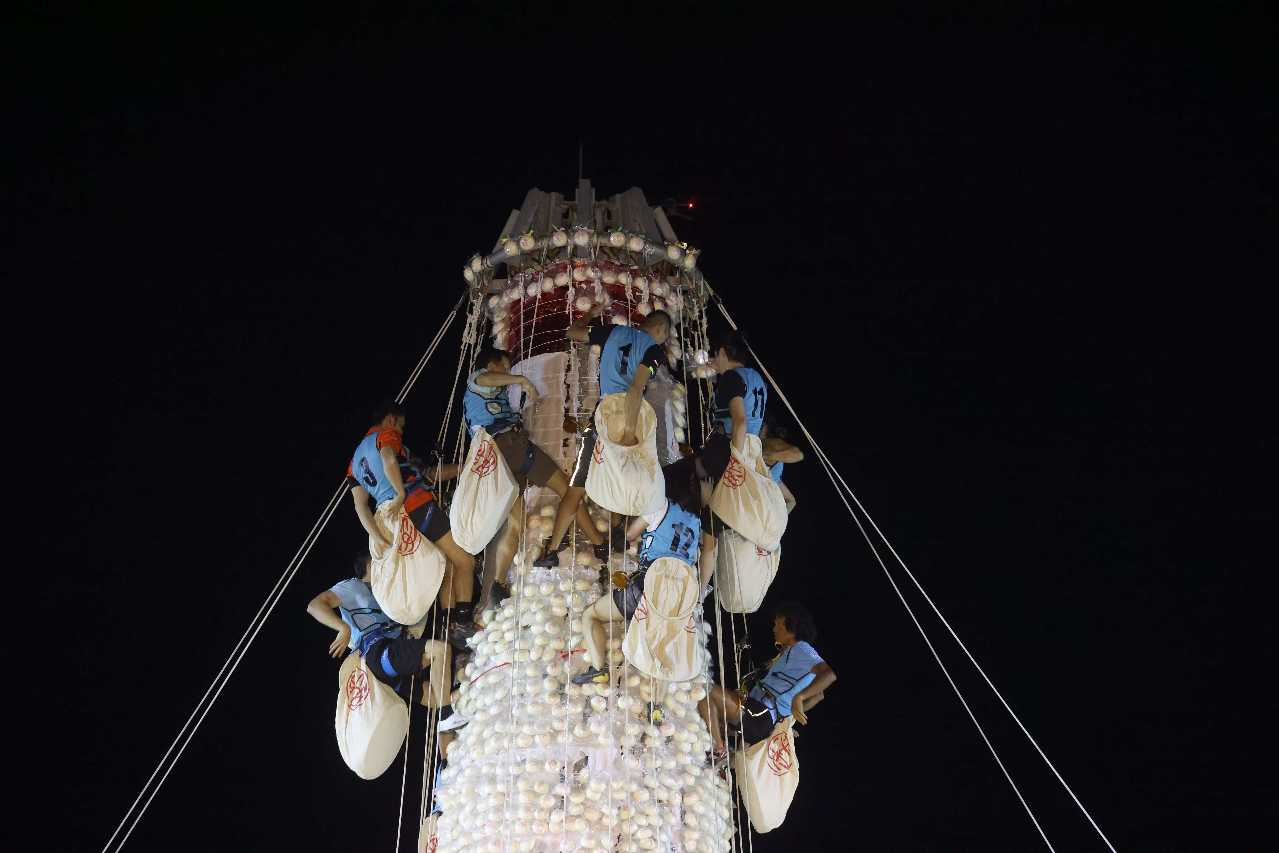 Competitors scramble up a bamboo bun tower to collect imitation Ping On buns during the annual Bun Festival in Cheung Chau. Photo: Yik Yeung-man