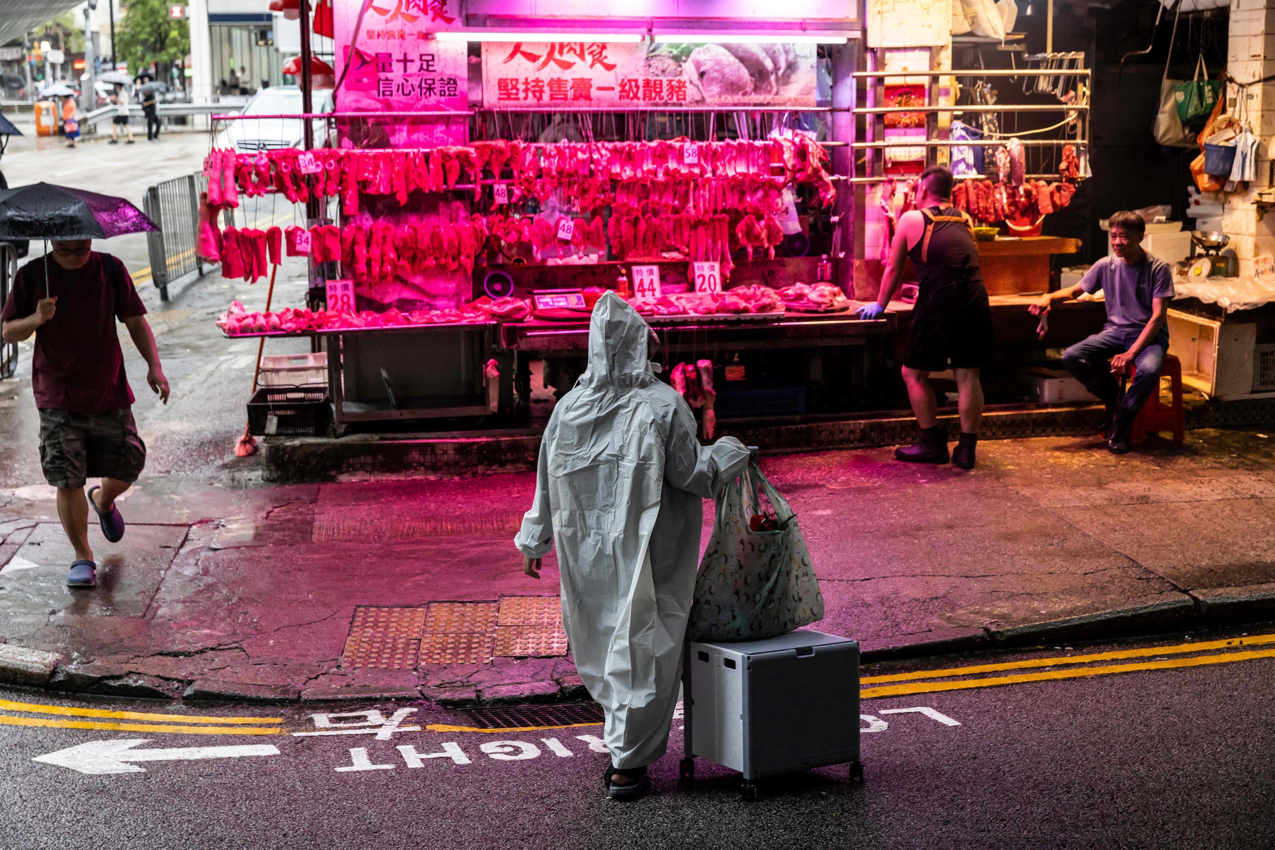 A woman protects herself from the rain in Hong Kong, as Typhoon Podul weakens to a severe tropical storm. Photo: AFP