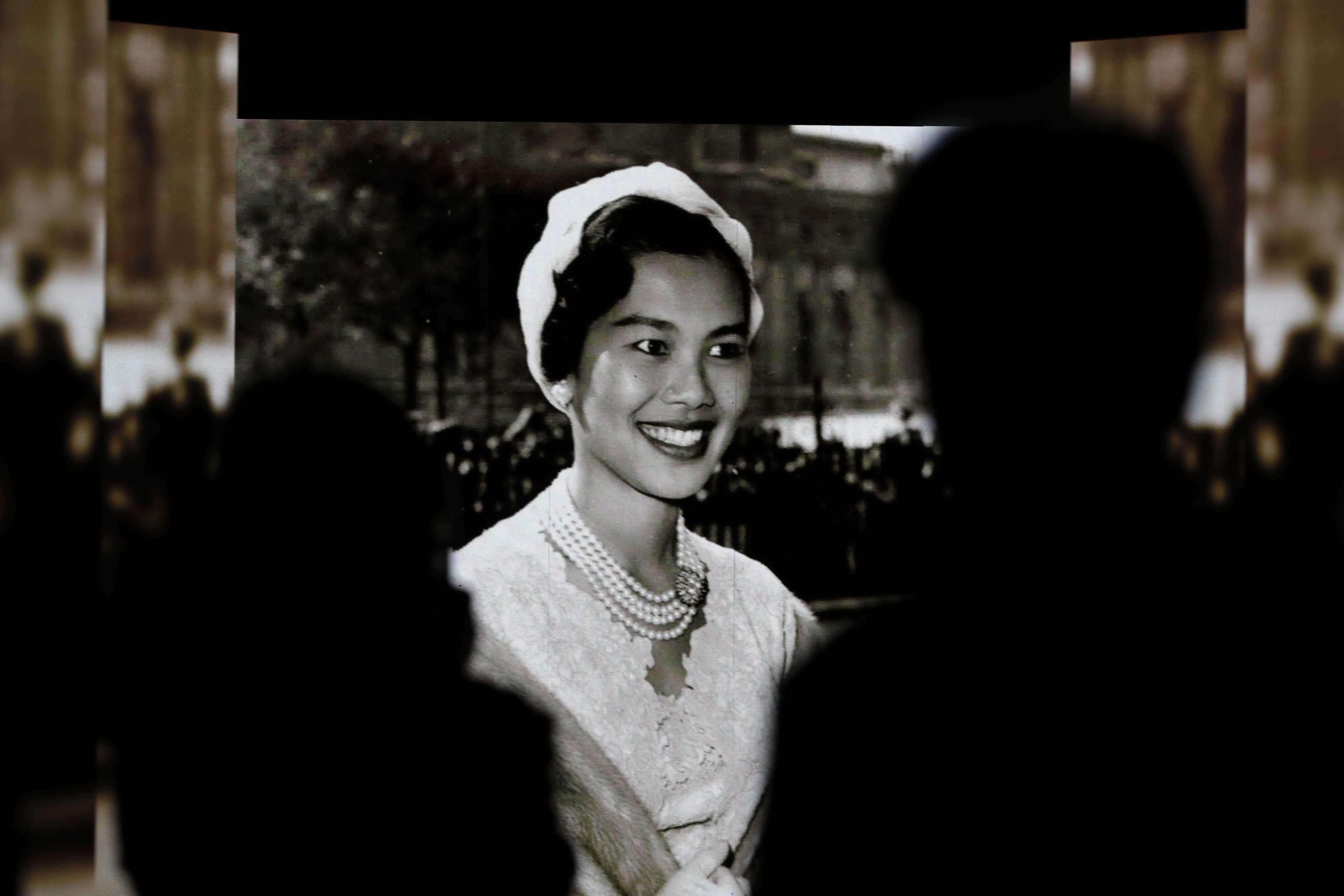 Thai mourners watch a video presentation honouring Queen Mother Sirikit following her death at the Queen Sirikit Museum of Textiles inside the Grand Palace in Bangkok, Thailand. Photo: EPA
