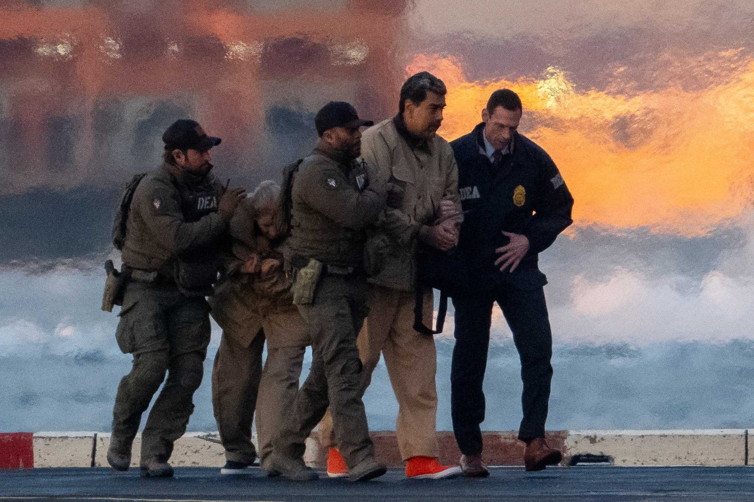 Venezuelan President Nicolas Maduro and his wife Cilia Flores are forcibly escorted by US forces after being abducted from their home. Photo: Reuters