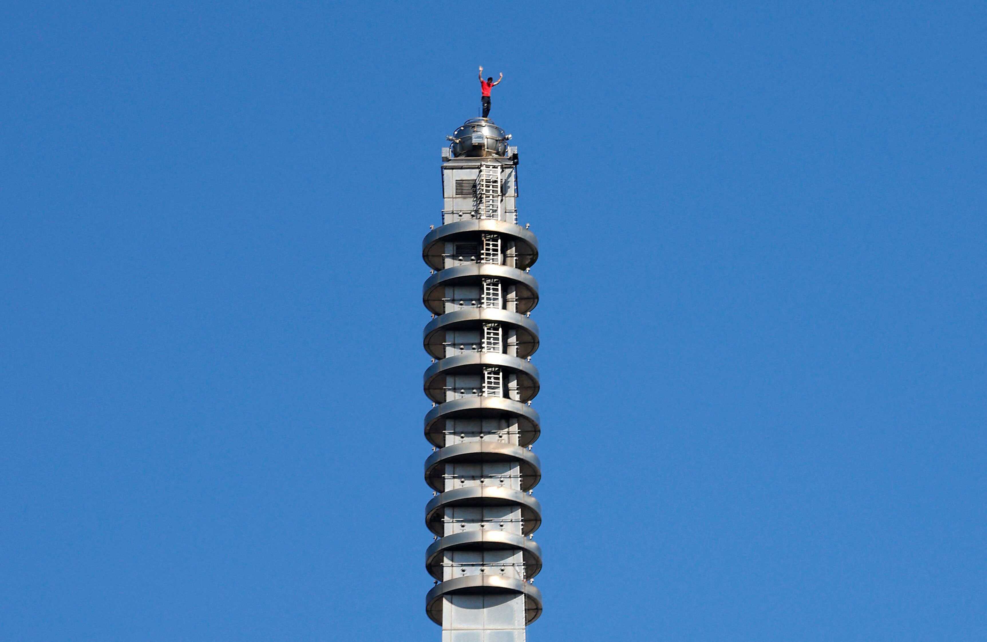 US climber Alex Honnold waves from the top of Taipei 101 after successfully scaling the building without ropes. Photo: Reuters