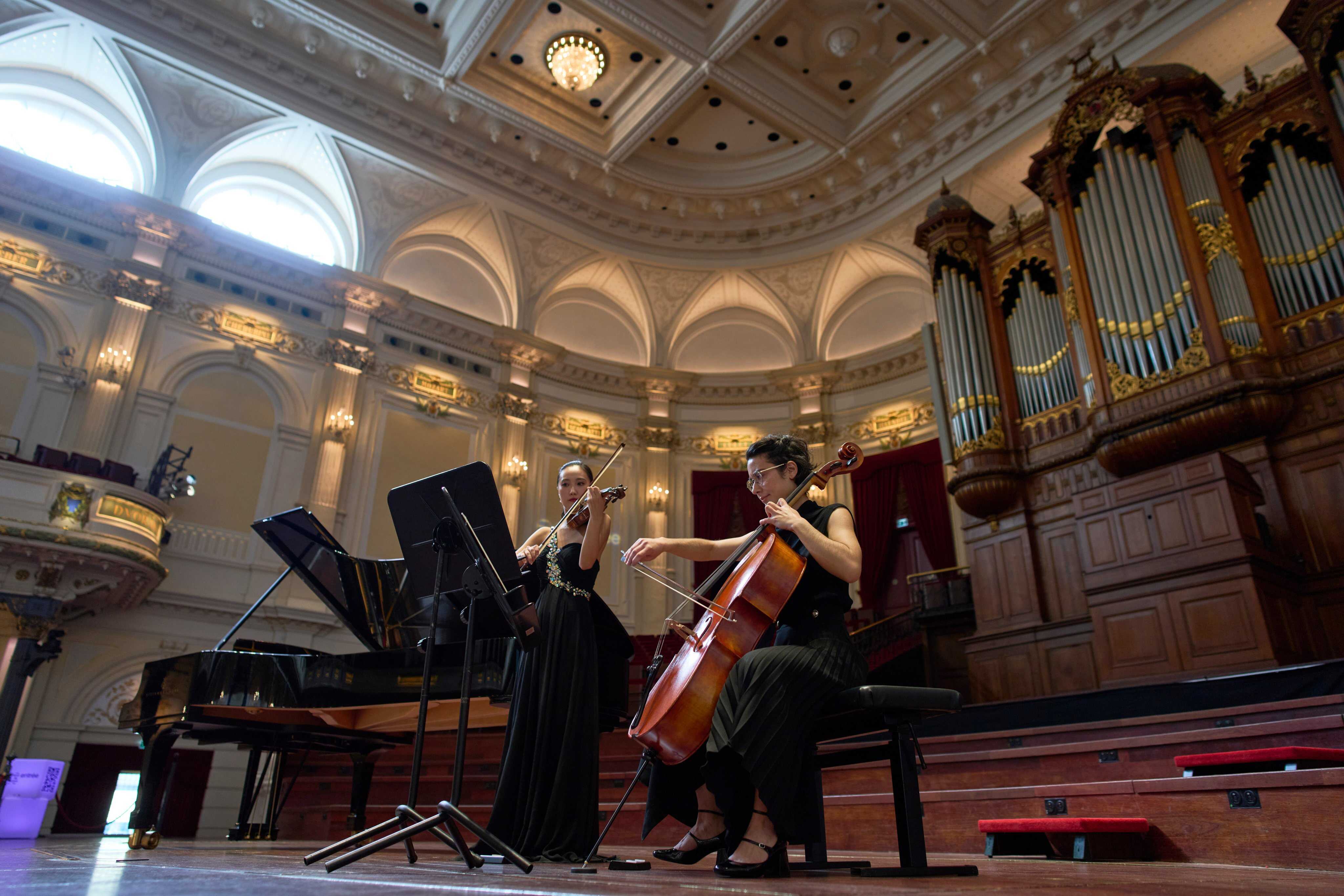 Violinist Hyunjin Cho, left, and cellist Efstratia Chaloulakou perform for students studying with music at Concertgebouw in Amsterdam, the Netherlands. Photo: AP
