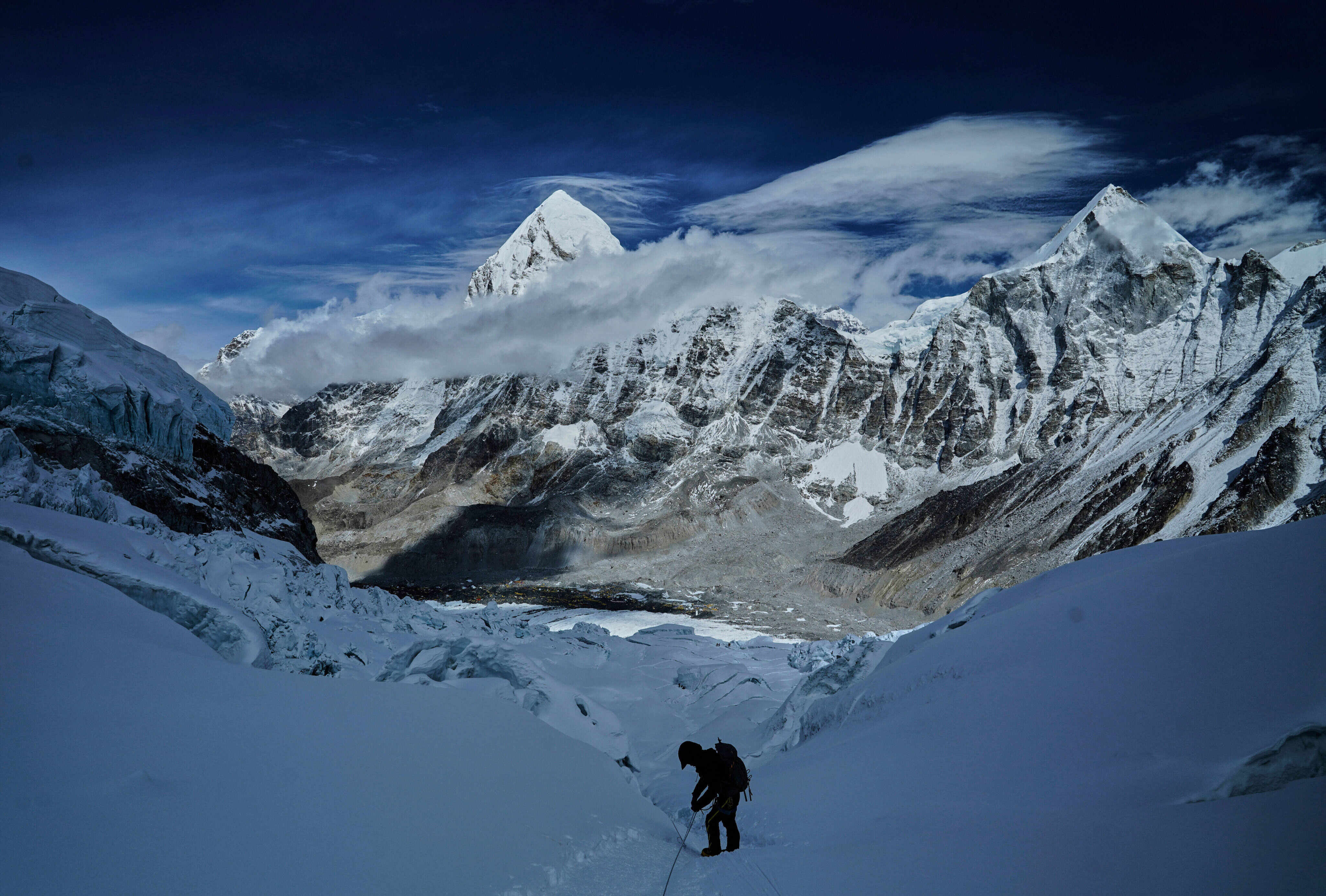 Mount Pumori, centre left, looms in the background as a mountaineer navigates the dangerous Khumbu Icefall to descend to Everest Base Camp. Photo: AP