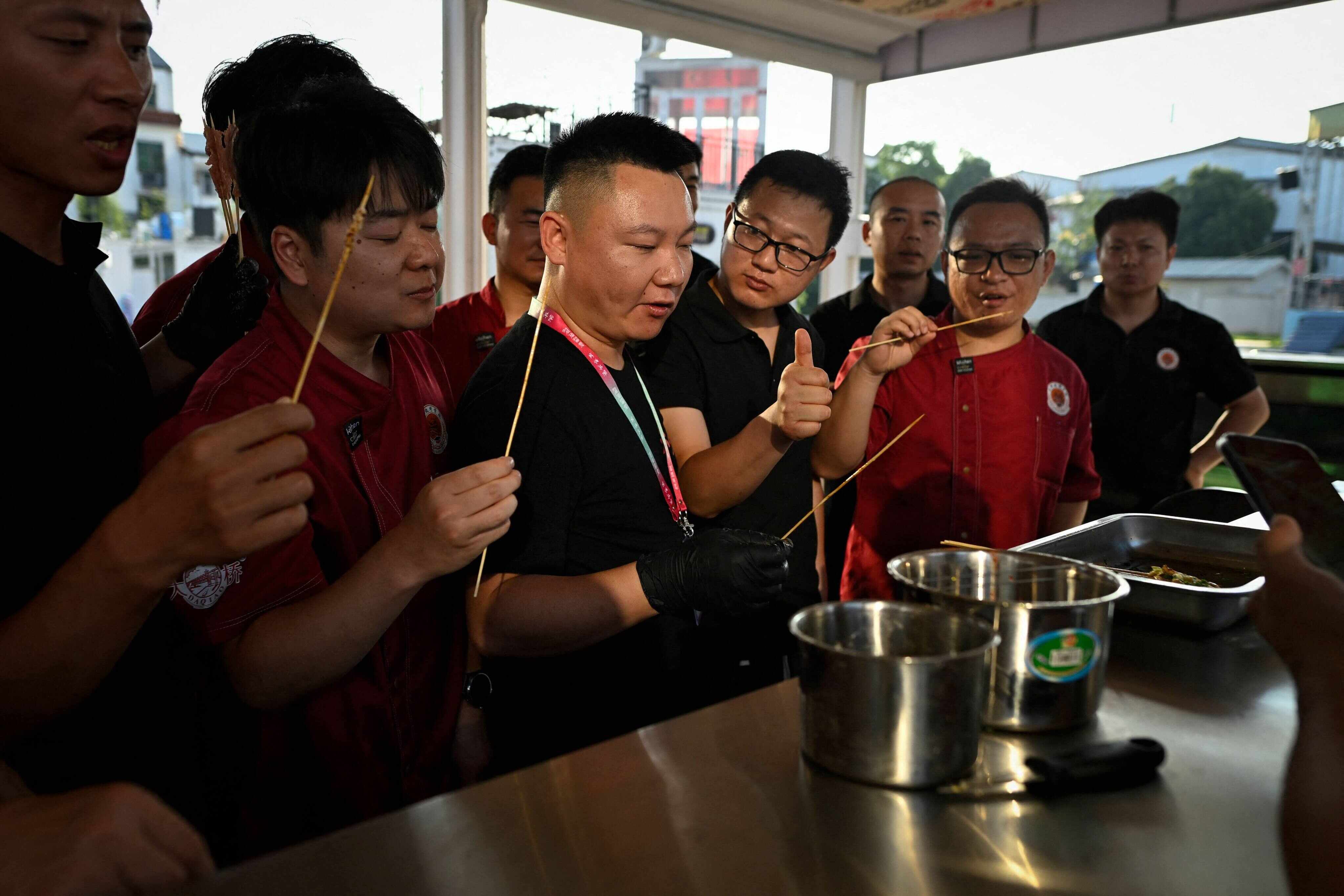 A trainer at the Yueyang Barbecue Academy (centre) tastes skewers with a group of trainees at the institution in Yueyang, in China’s Hunan province. Photo: AFP