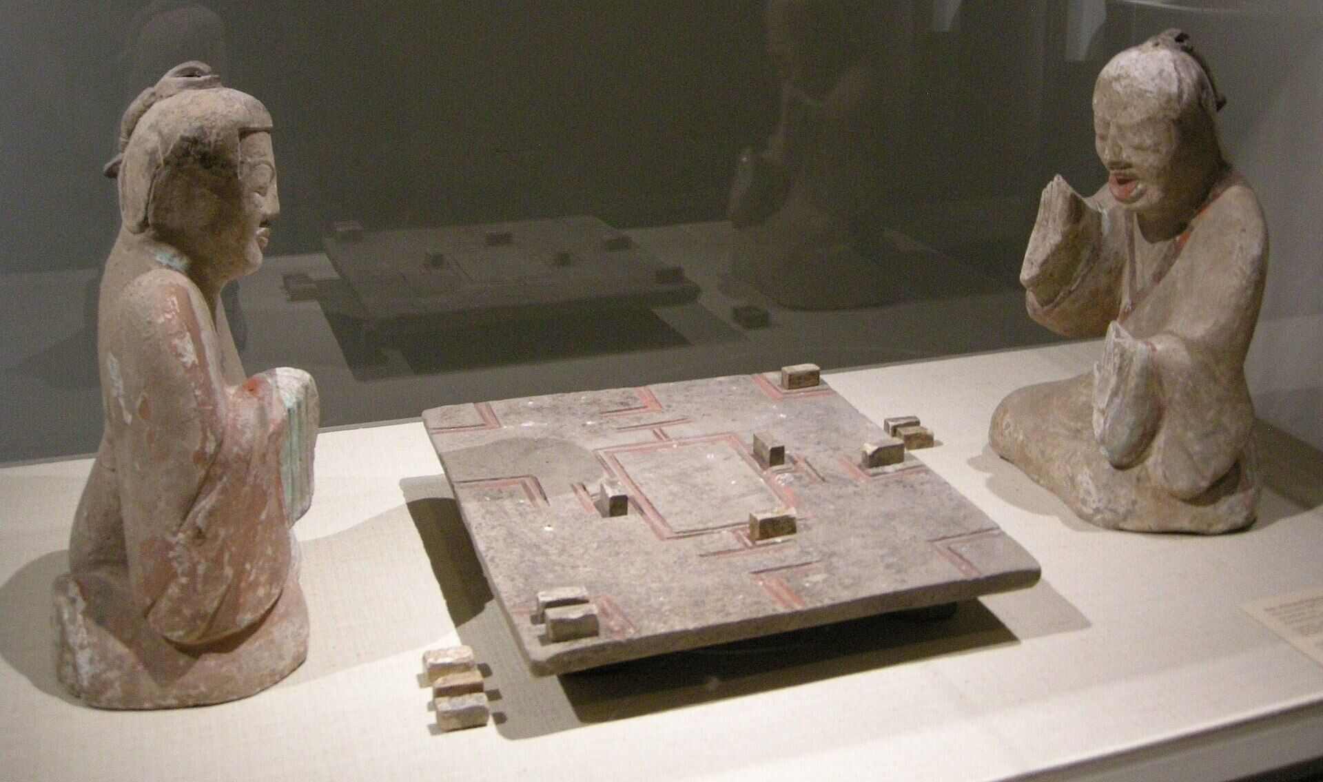 This Han dynasty earthenware sculpture at The Met captures two figures in a tense game of Liubo. Photo: Wikipedia