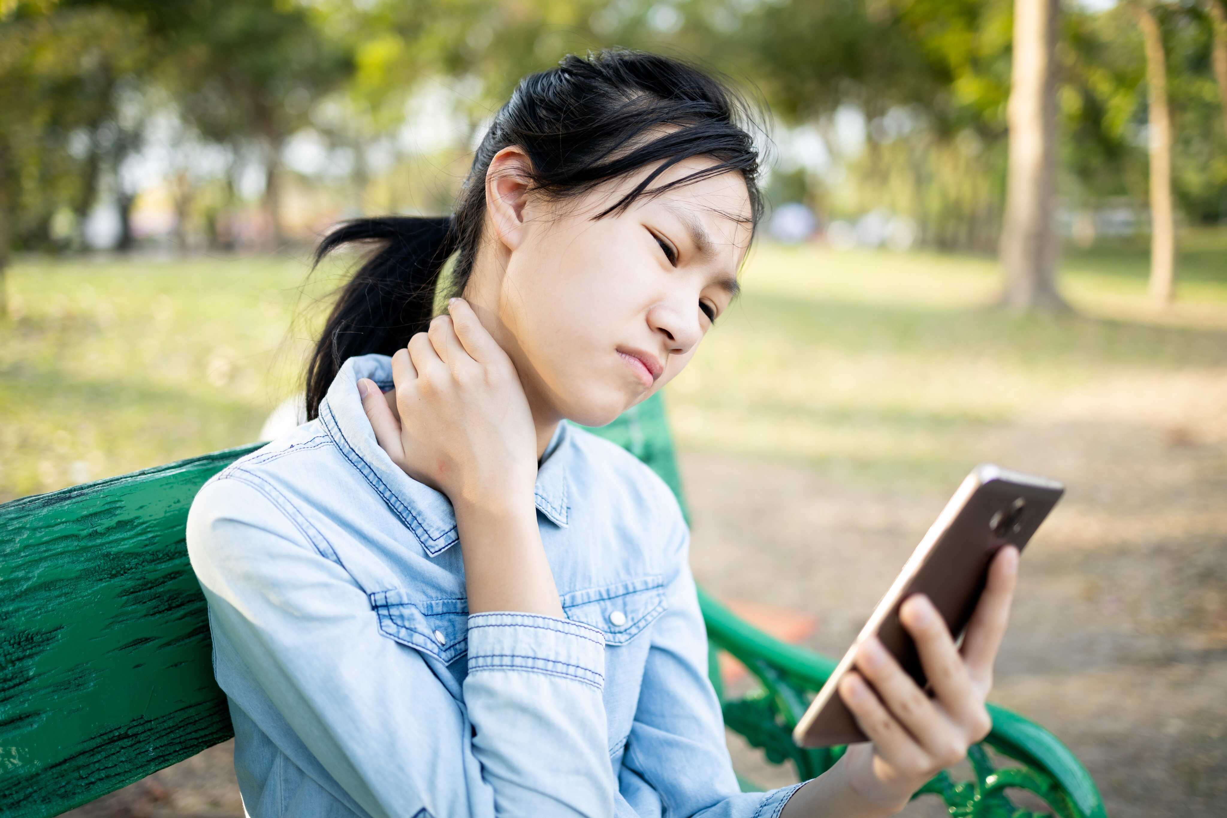 Staring down at your phone for too long can put strain on your neck. Photo: Shutterstock