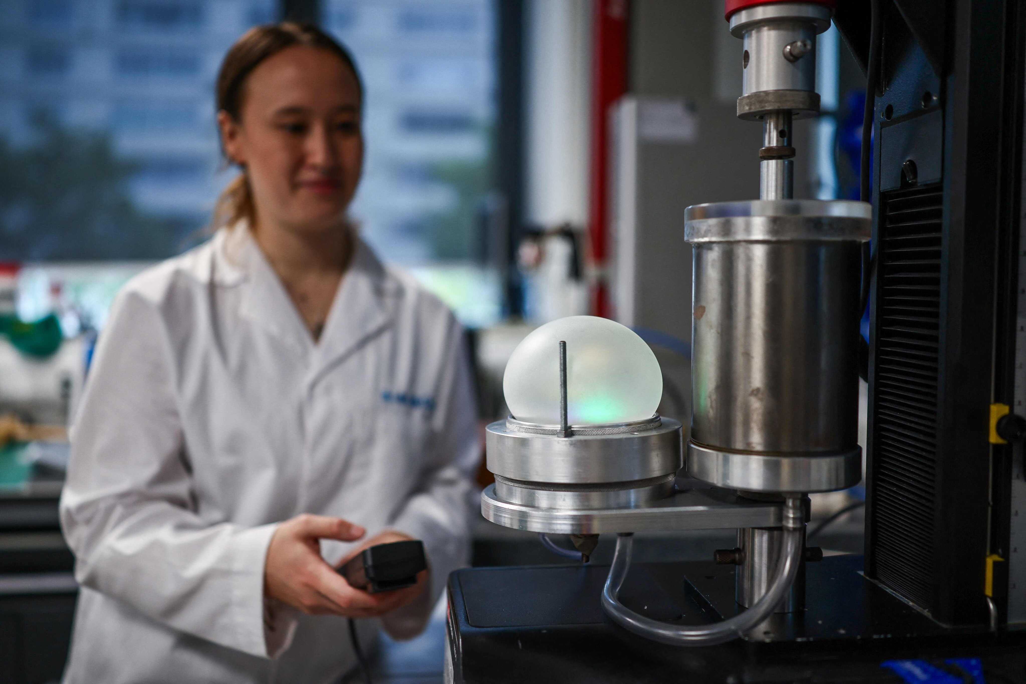 Researcher Juliana Cumming inflates her biodegradable rubber. Photo: AFP