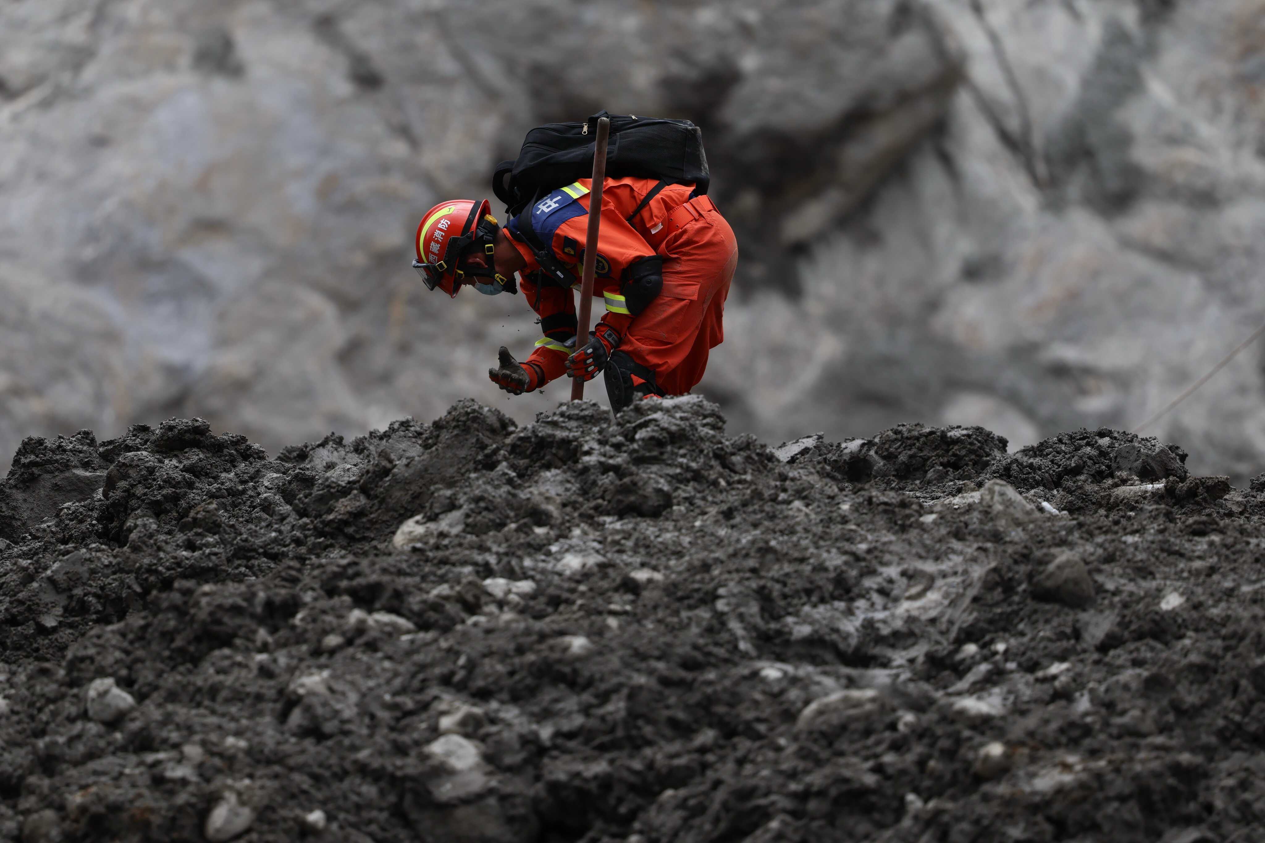 A worker uses his hand to dig during a search and rescue operation at the area that was once Gyirong Port, now wiped from existence, in China’s Tibet autonomous region. Photo: AP