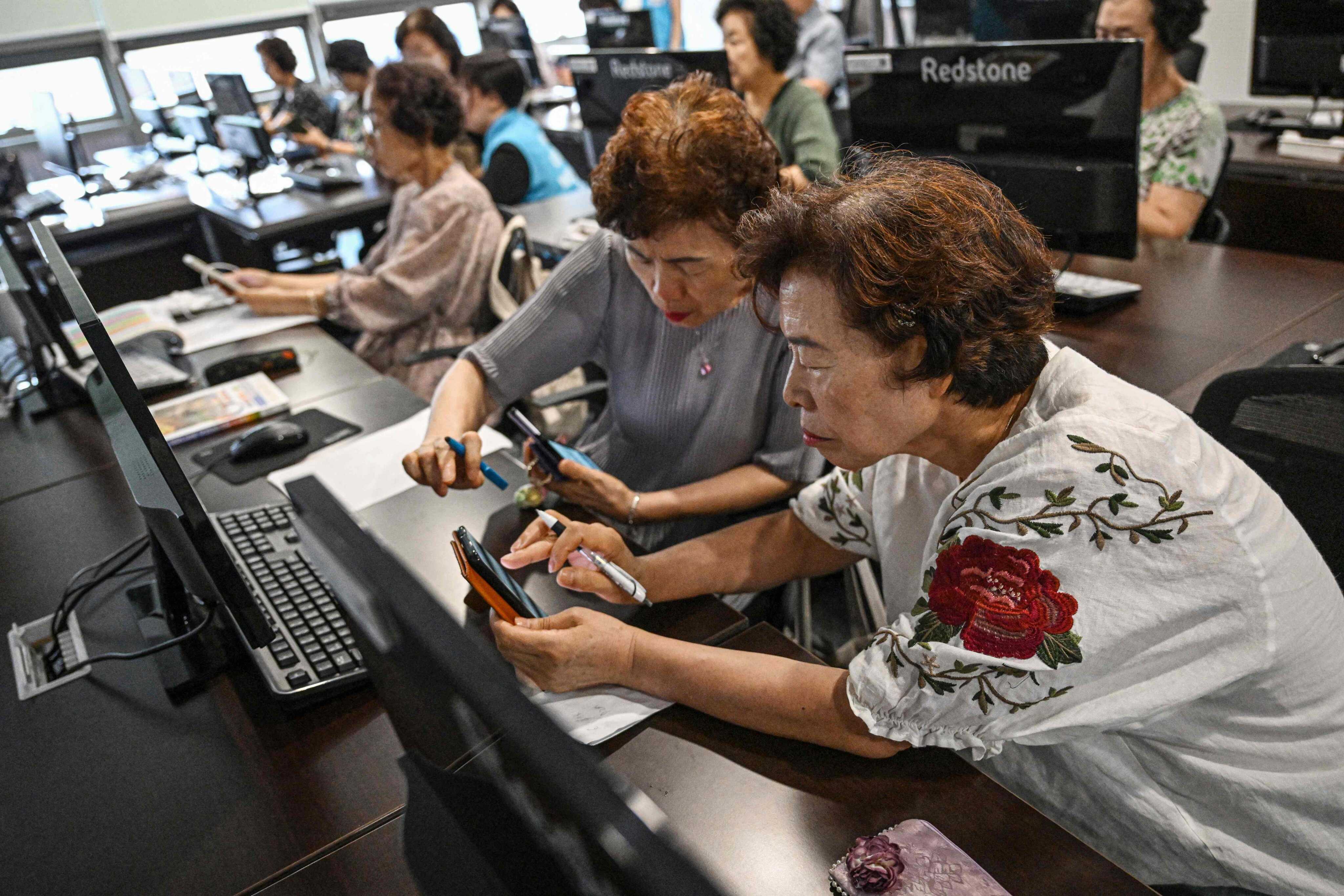 Elderly South Koreans attend a class on navigating AI-powered applications in Seoul in July. South Korea’s new “AI for All” initiative aims to give every citizen free AI access. Photo: AFP