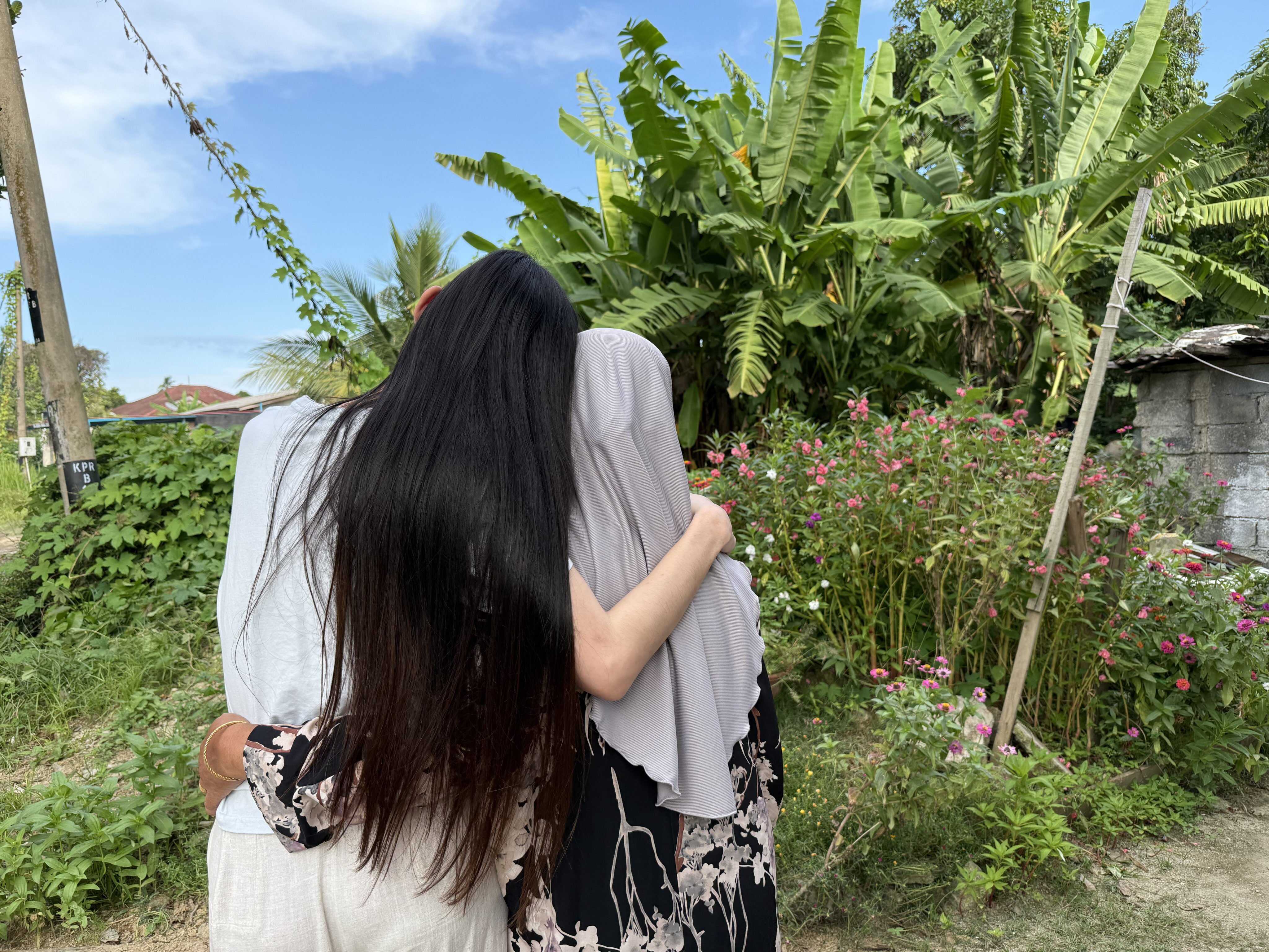 Hana* (left) embraces her mother outside their home in a village near Kota Bharu, Malaysia’s Kelantan state. Photo: Iman Muttaqin Yusof