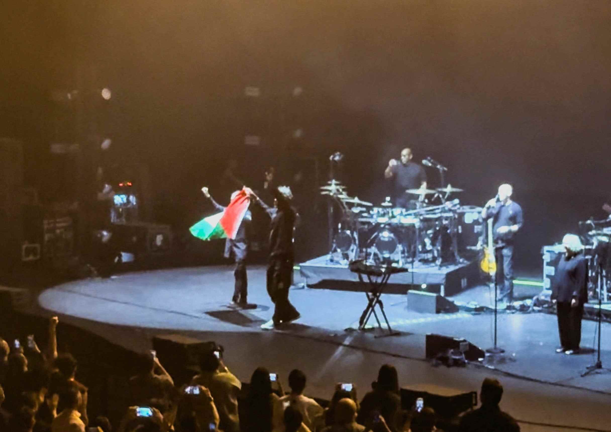 Robert Del Naja and Grant Marshall from Massive Attack stand with a Palestinian flag onstage at the end of their performance in Singapore on July 29. Photo: Simran Panaech via Reuters