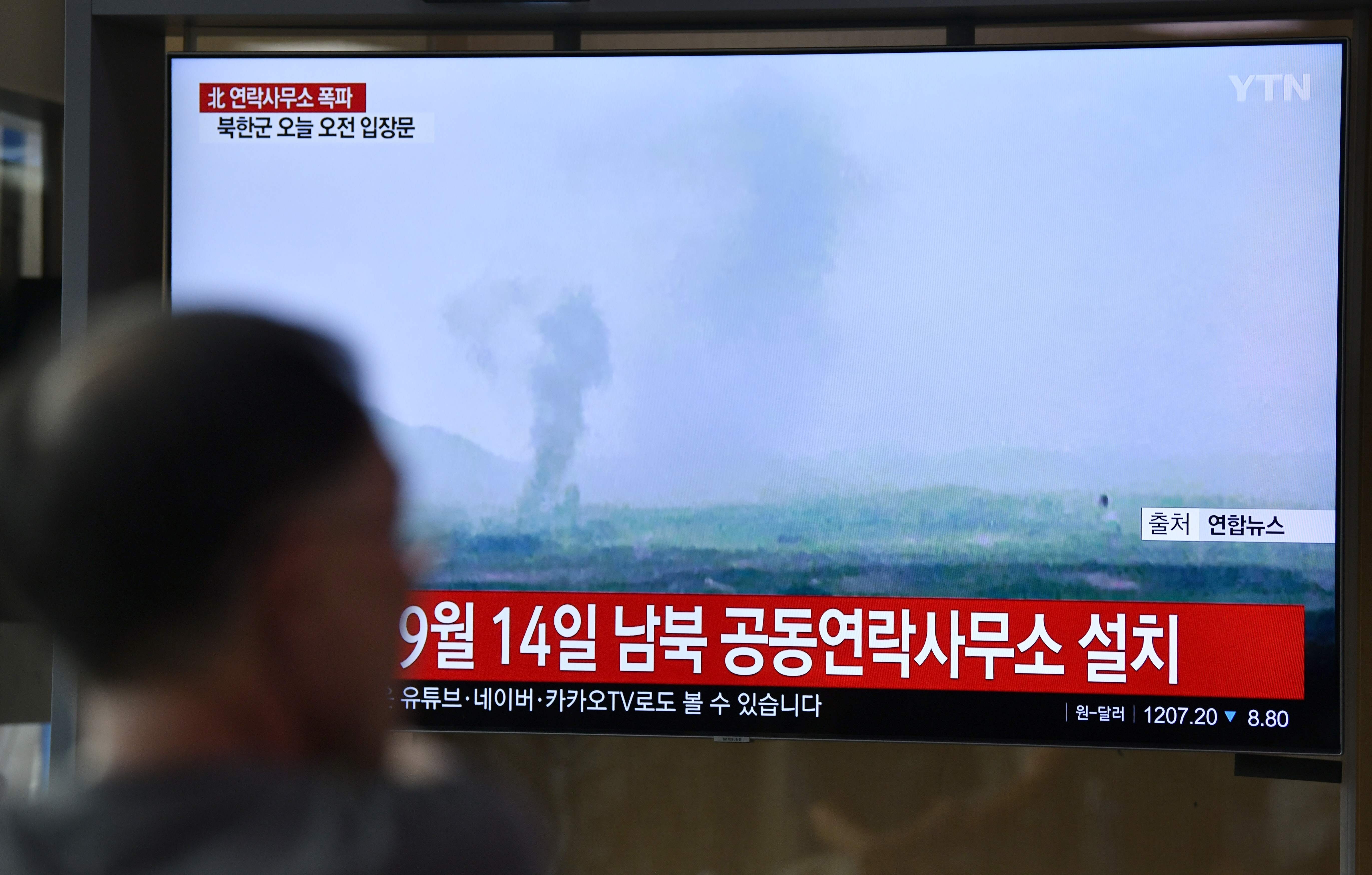 People watch a television news screen showing an explosion of an inter-Korean liaison office in North Korea's Kaesong Industrial Complex, at a railway station in Seoul. (Photo by Jung Yeon-je / AFP)