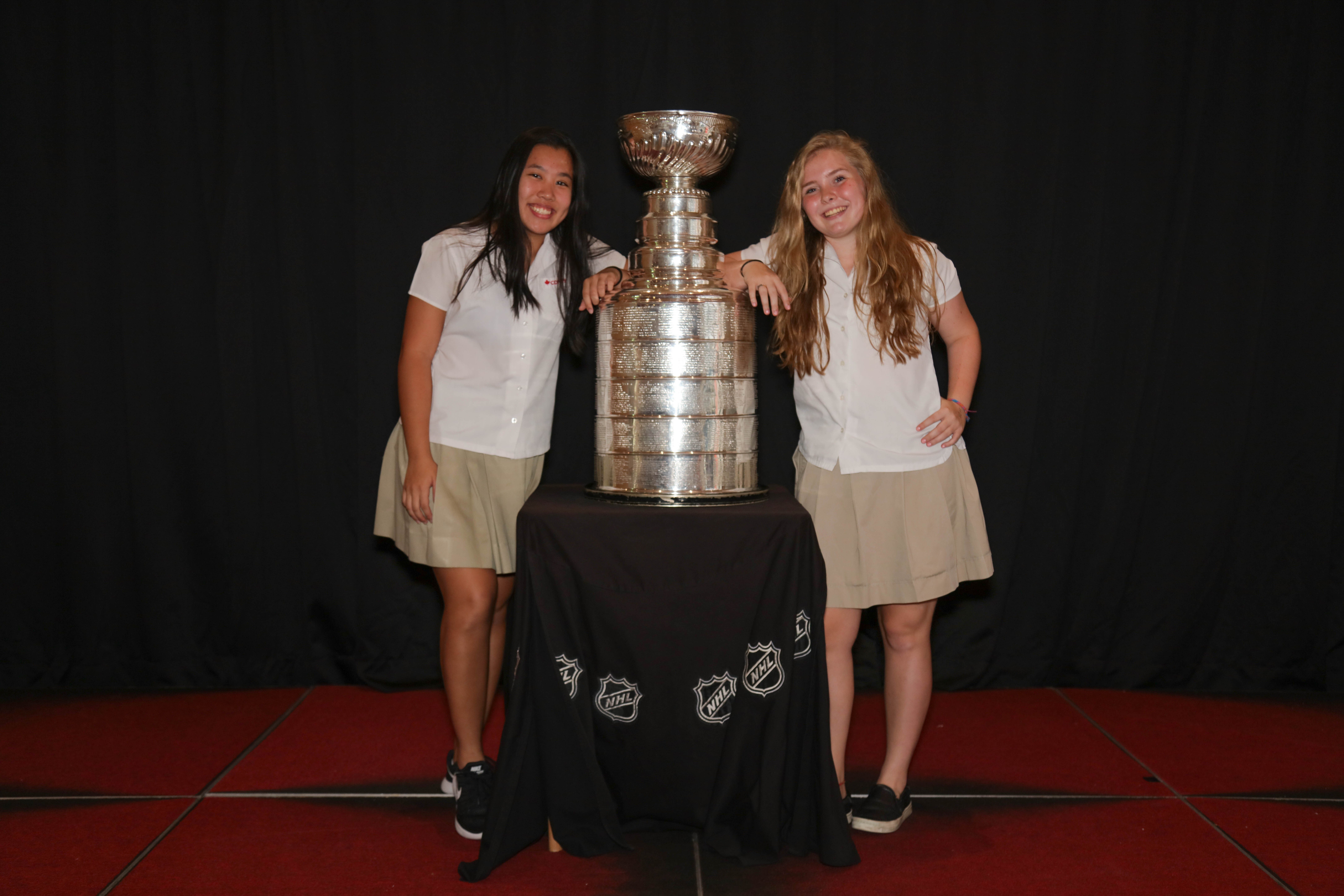 Elise Bland (right) and Monica Shum (left) pose next to the legendary Stanley Cup. 