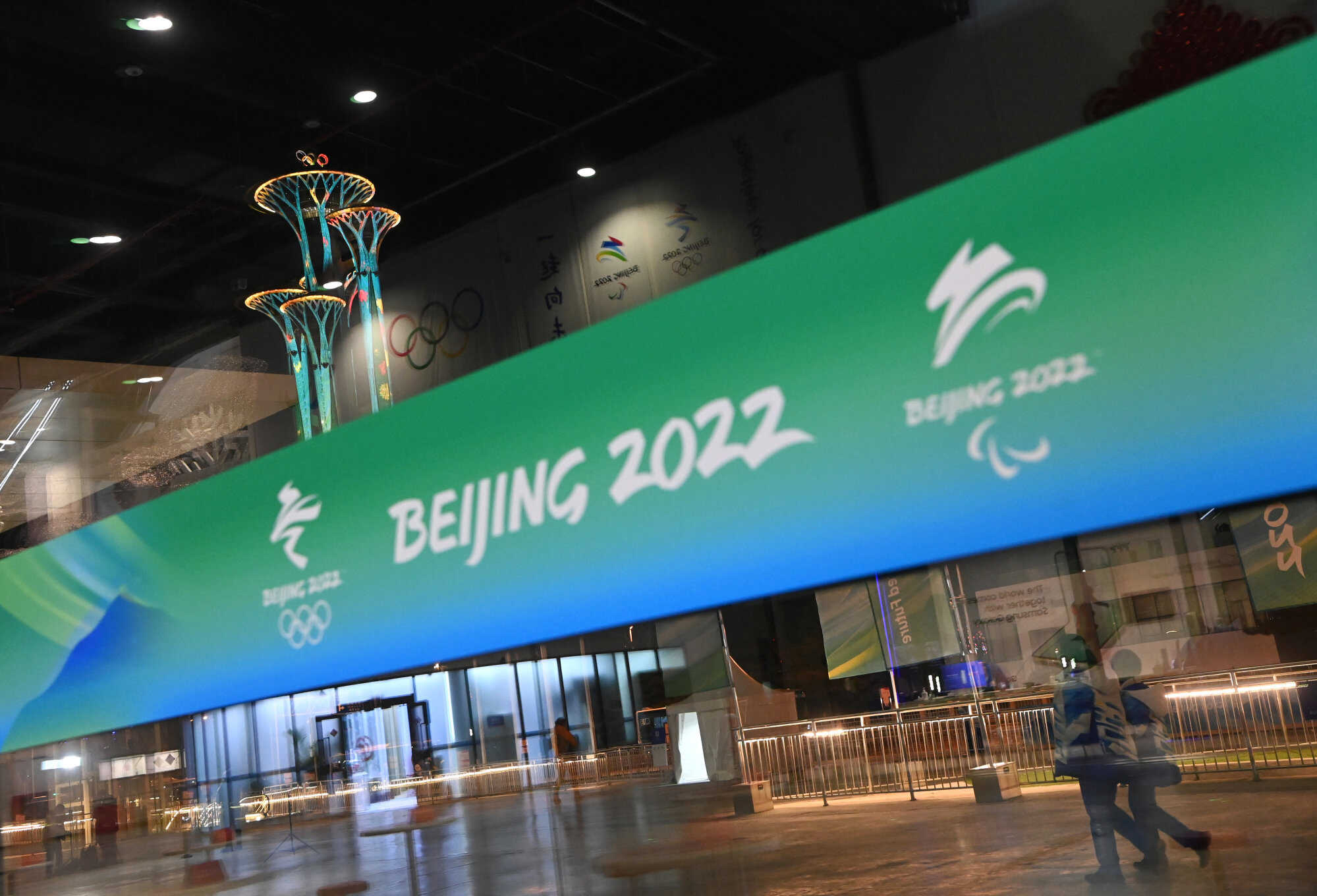 Staff members walk outside the main media centre for the Winter Olympics in Beijing. Photo: Xinhua
