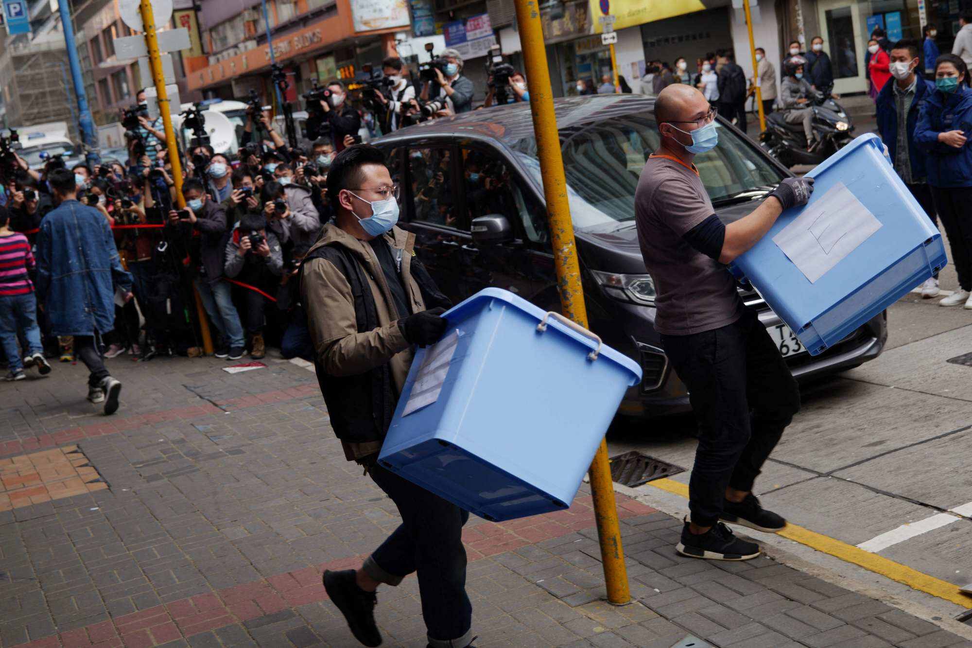 This file photo taken on December 29, 2021 shows a Hong Kong National Security police officer (C) and a worker (R) carrying boxes of evidence from the offices of Stand News in Hong Kong after police raided the office of the local media outlet and arrested six current and former staff. Photo: AFP