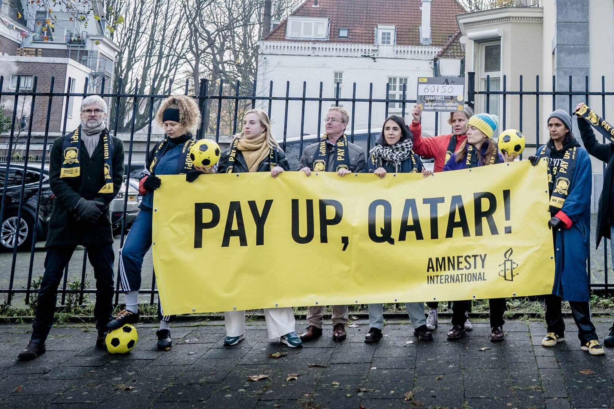 Members of Amnesty International hold a banner outside the Qatar embassy in The Netherlands, calling on the country and Fifa to compensate the migrant workers who made the World Cup possible. Photo: AFP