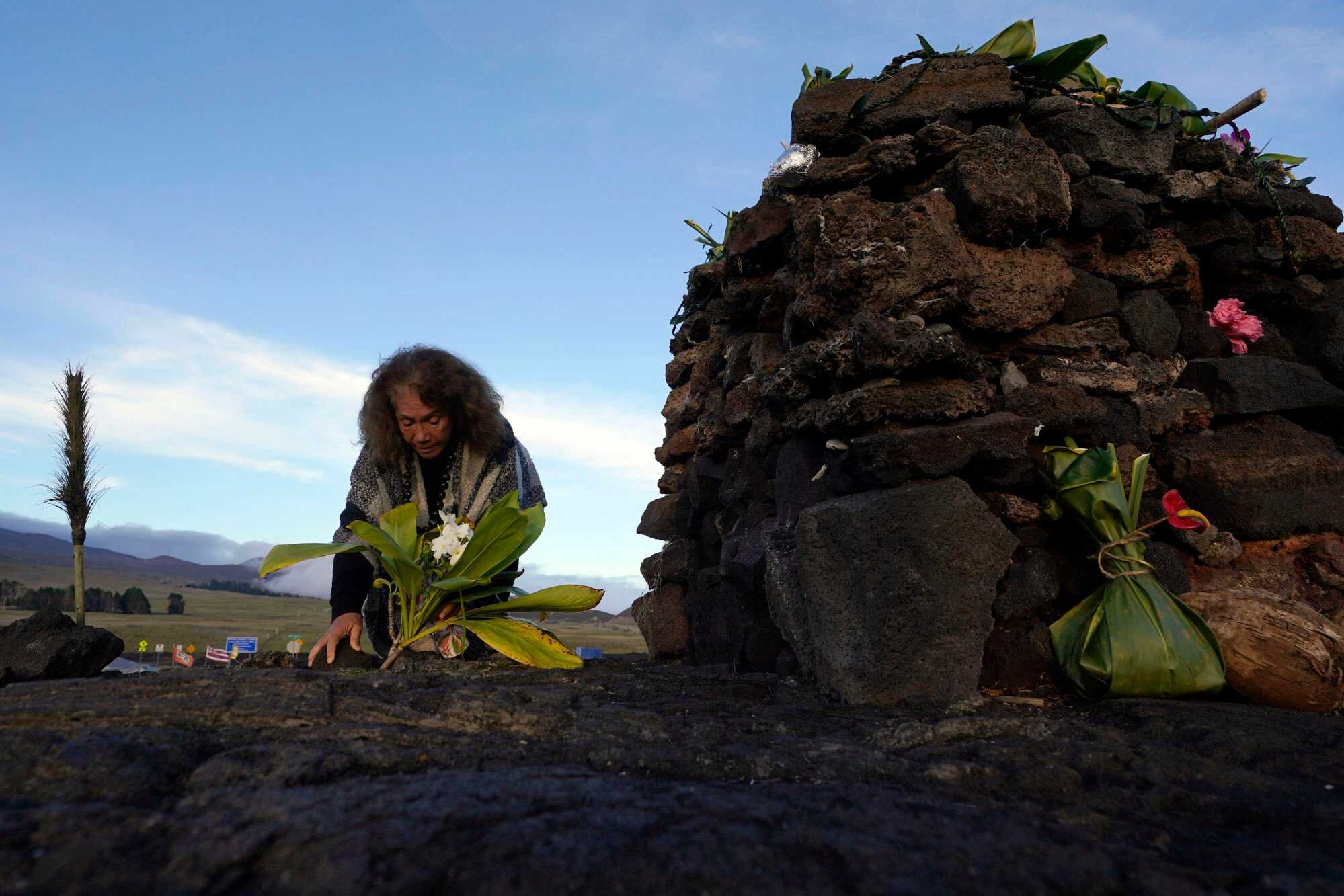 Illona Ilae, a Native Hawaiian, leaves an offering in front an alter below the Mauna Loa volcano as it erupts. Photo: AP