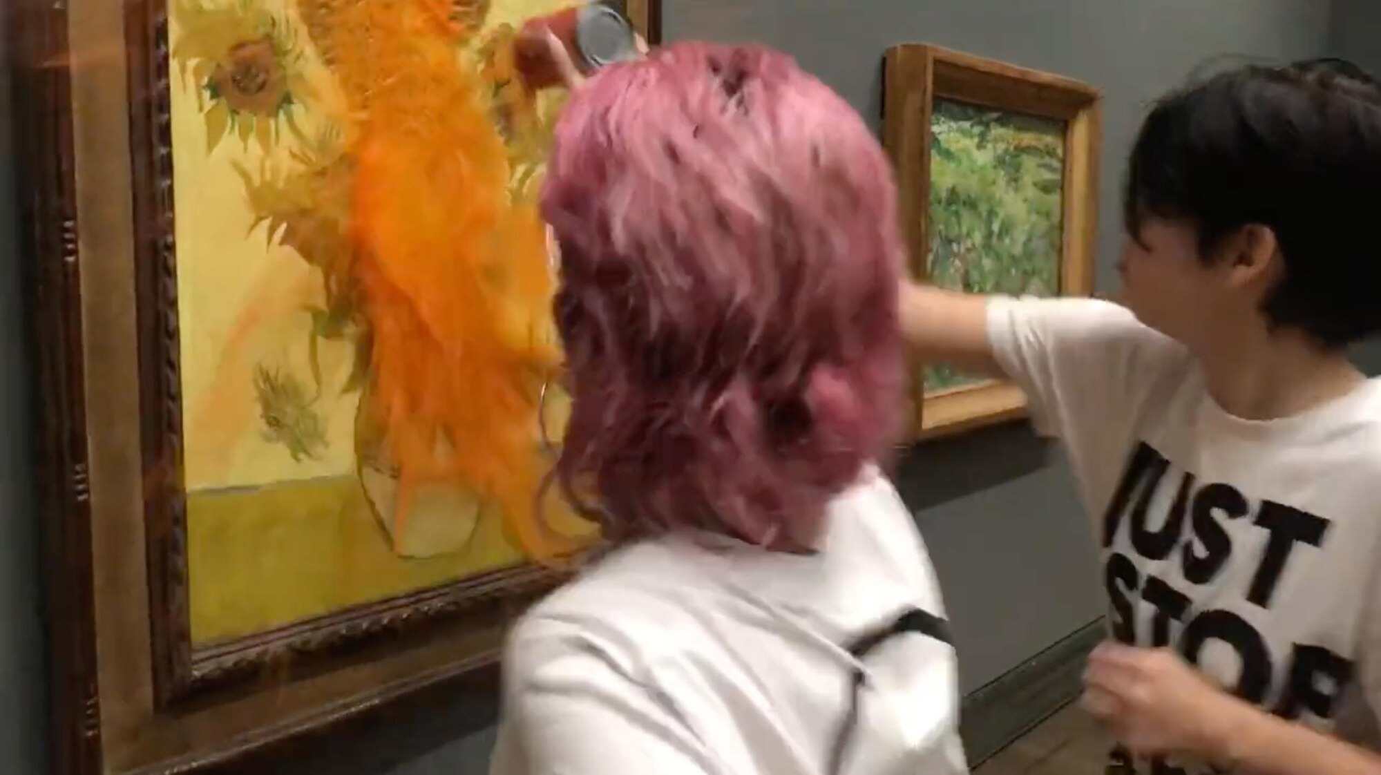 A handout photo made available by the “Just Stop Oil” climate activism group shows the two protesters who threw tomato soup at Vincent van Gogh’s 1888 painting “Sunflowers” at the National Gallery in London. Photo: EPA-EFE