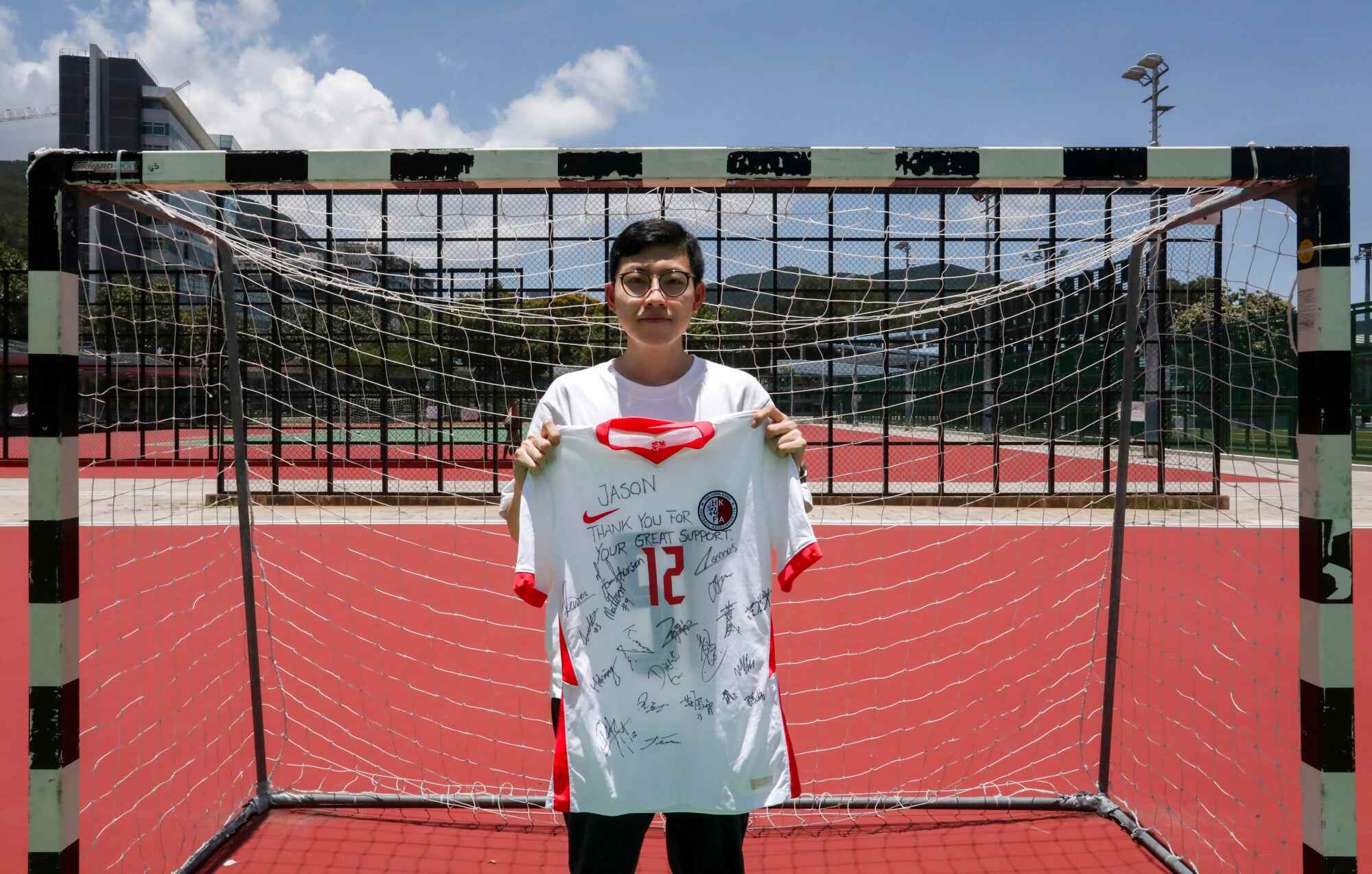 Jason Yau holds a jersey signed by Hong Kong’s football team who gave this to him as a gift. It reads: “Jason, thank you for your great support”. Photo: Jonathan Wong