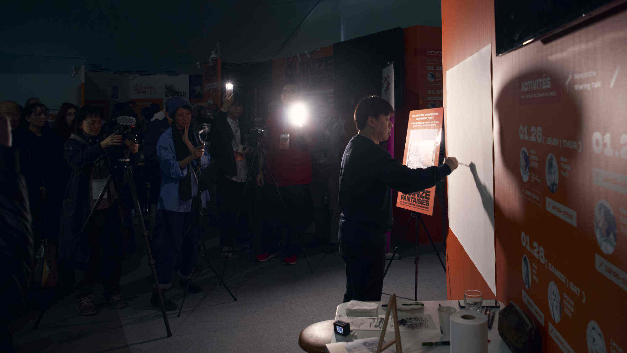 During a live sketch session, Cheung Hon-wah draws with only the light from phones in the audience. Photo: Handout