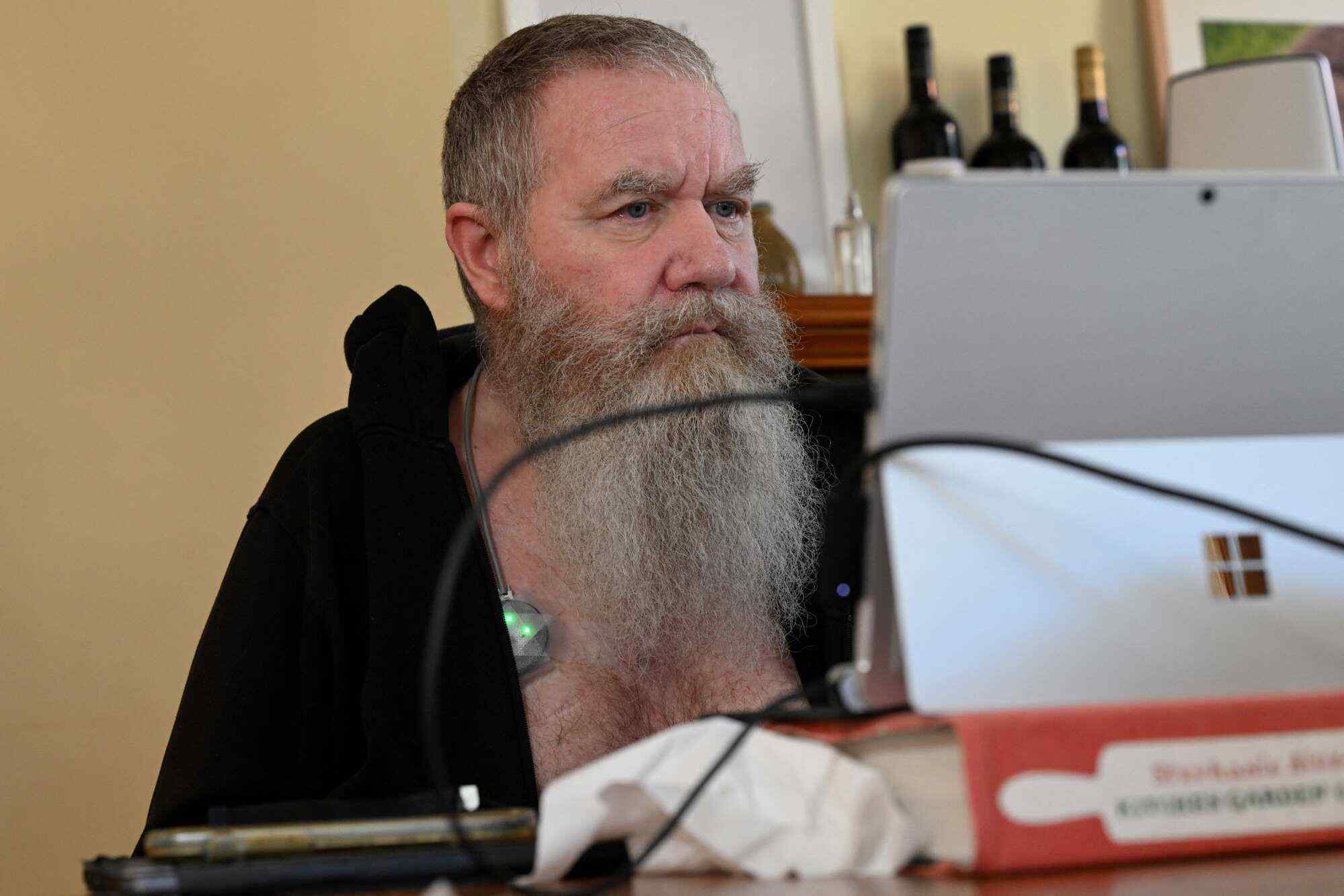 A photo taken on August 3, 2023 shows Rodney Gorham, a recipient of a Synchron brain implant, working on a computer at his home in Melbourne. As a rare form of Lou Gehrig’s disease paralyses his body, Gorham hopes the pioneering link between his brain and a computer will help others after he is gone. Photo: AFP