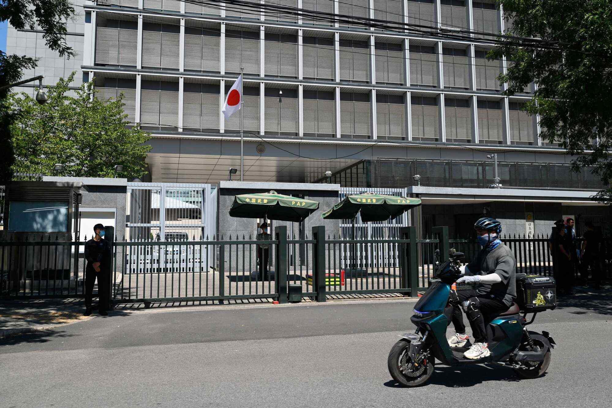 A man rides his motorcycle past the entrance of the Japanese embassy in Beijing on August 29, 2023. Japan called the harassment being faced by Japanese citizens in China “extremely regrettable”, confirming that a brick was thrown at the country’s embassy in Beijing. Photo: AFP
