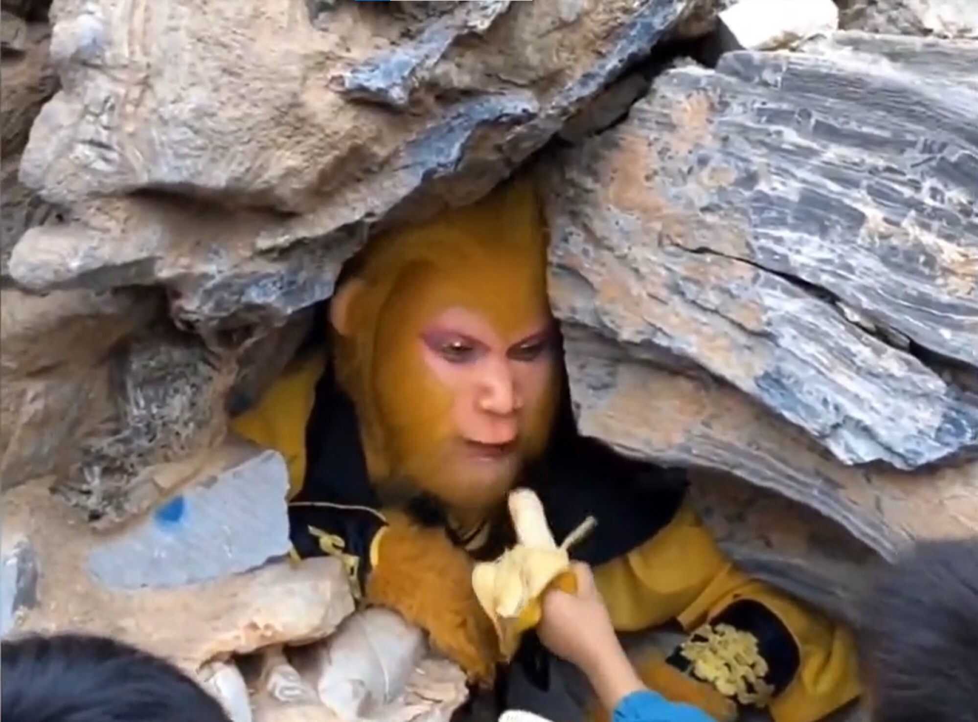 Children at a theme park in China feed bananas to someone dressed in a Monkey King costume. Photo: Captured from Toutiao