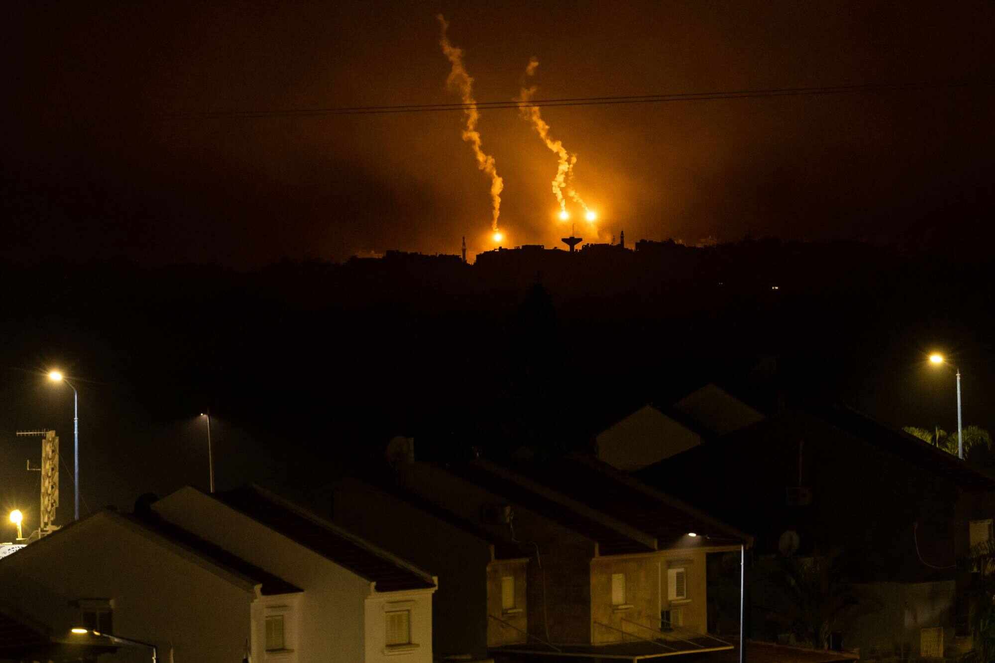 This picture taken from a position near Sderot along the Israeli border with the Gaza Strip early on November 14, 2023, shows flares dropped by Israeli forces above the Palestinian territory. An online disinformation campaign has tried to downplay the horrors of the war. Photo: AFP