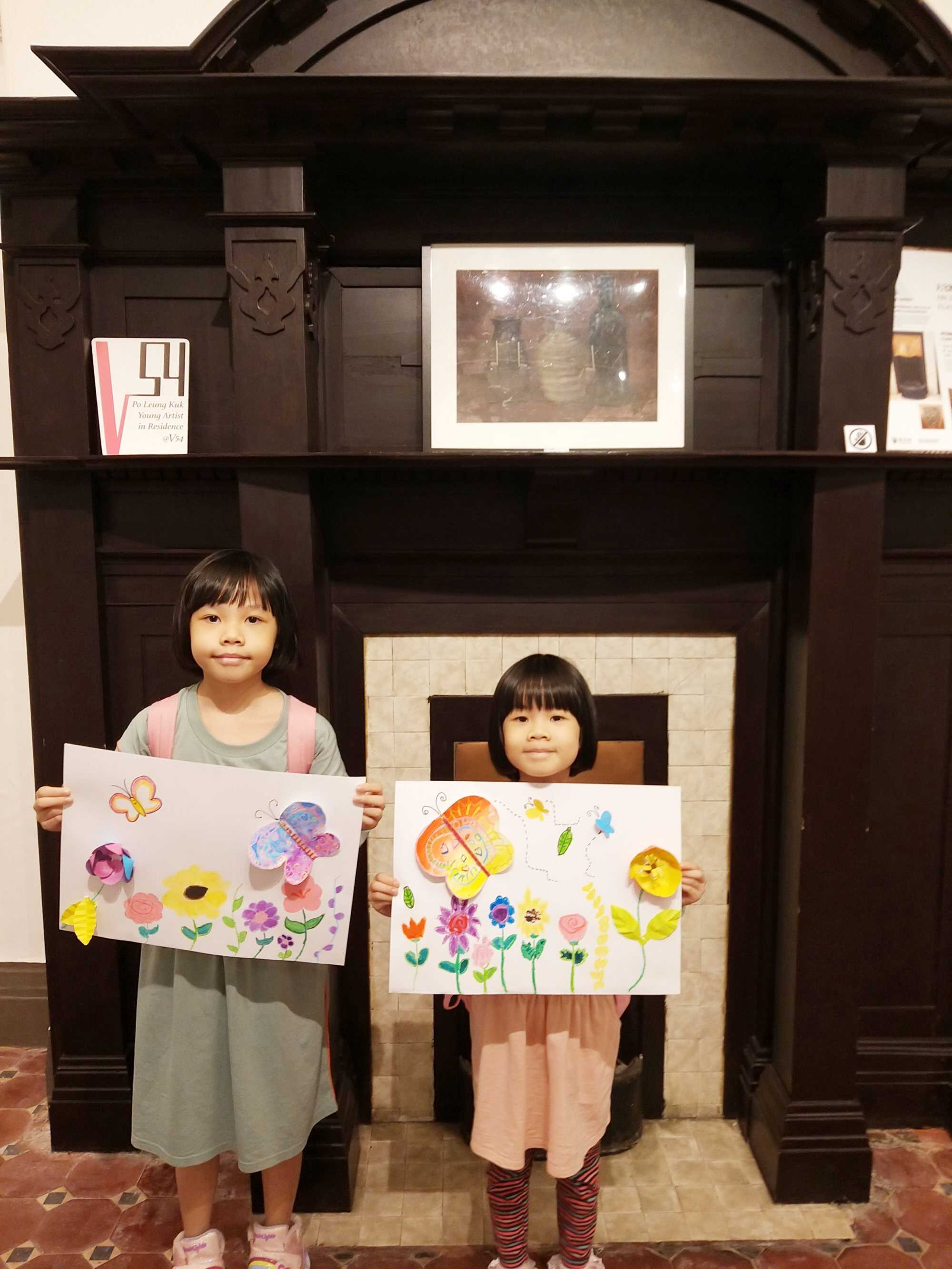 Marjorie Leung (left) shows off her drawing of flowers and butterflies. Photo: Handout