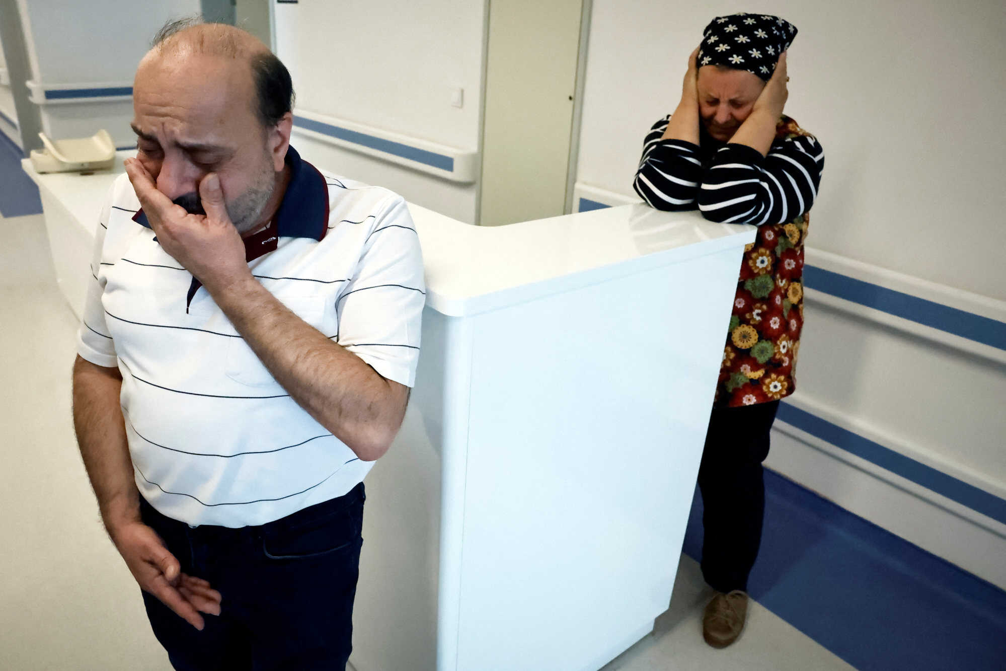 Hasan Koc and his late wife’s mother Emine Karalioglu in the hallway of Mersin Hospital, where his son Mehmet was treated after the earthquake. Photo: Reuters