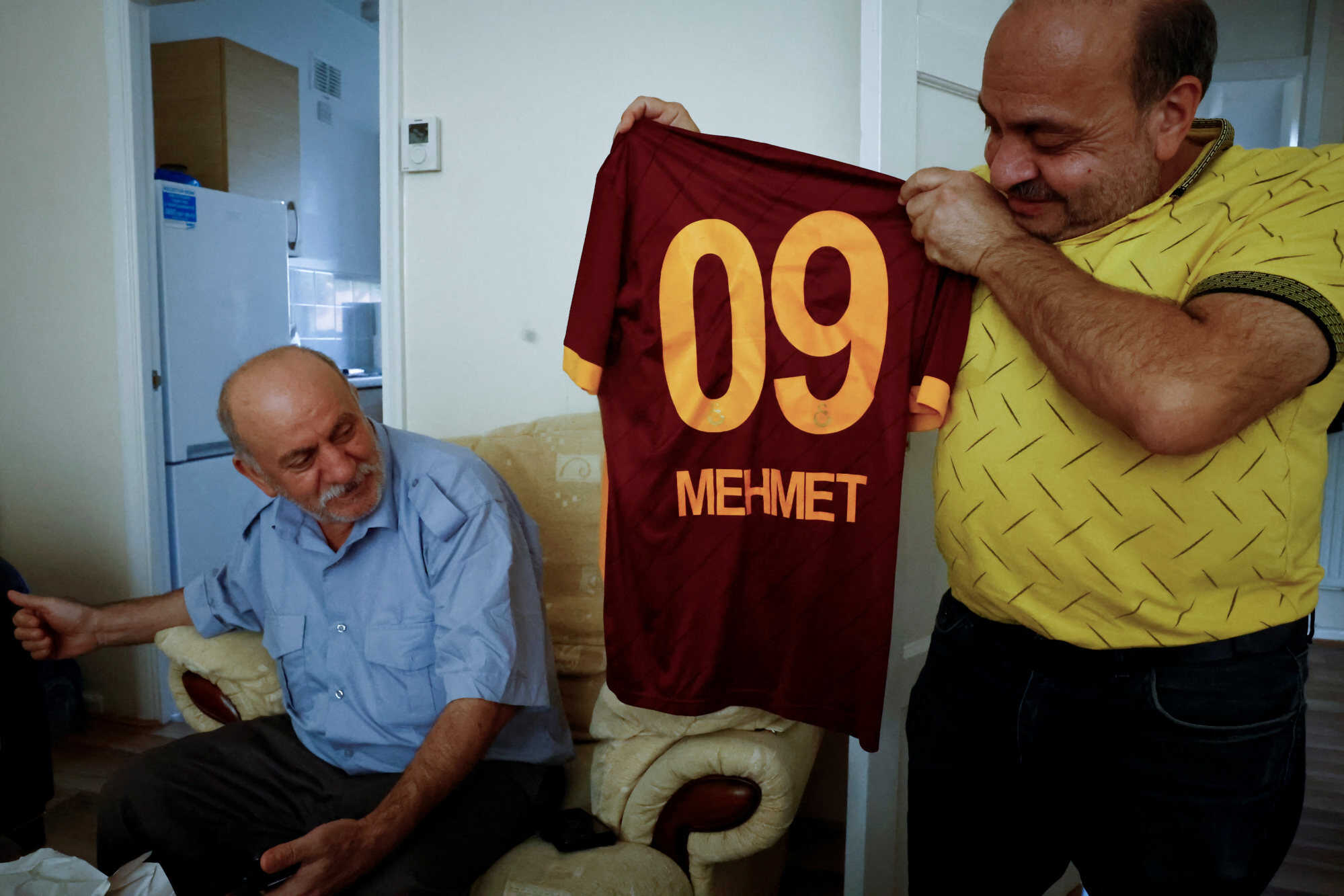 Hasan Koc holds up a Galatasaray football jersey with his son Mehmet’s name on it. Photo: Reuters