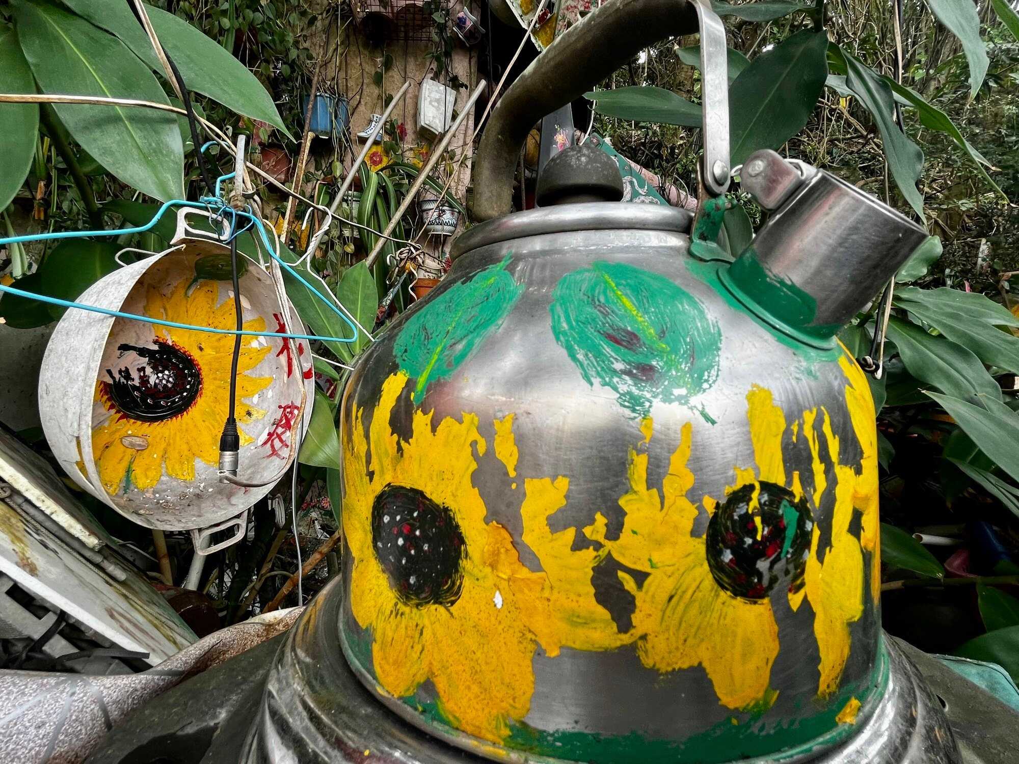 What makes Fapopo’s art so special is she uses everyday household items as a canvas, like this discarded kettle and bucket painted with sunflowers. Photo: Handout