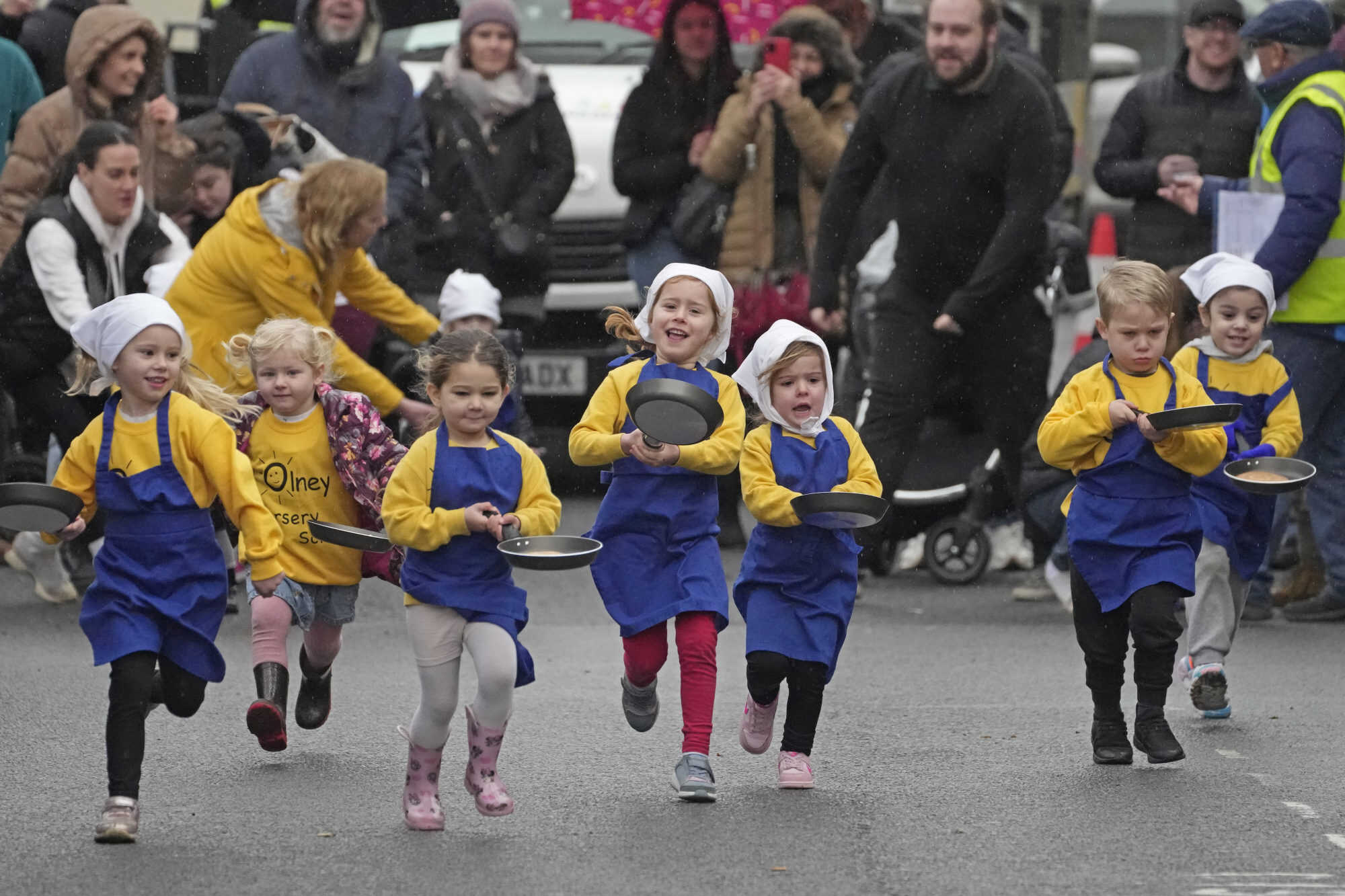 Schoolchildren from local schools take part in the children’s races prior to the annual Pancake Race in England. According to legend, the race started in 1445 when a harried housewife arrived at church on Shrove Tuesday still clutching her frying pan with a pancake in it. Photo: AP