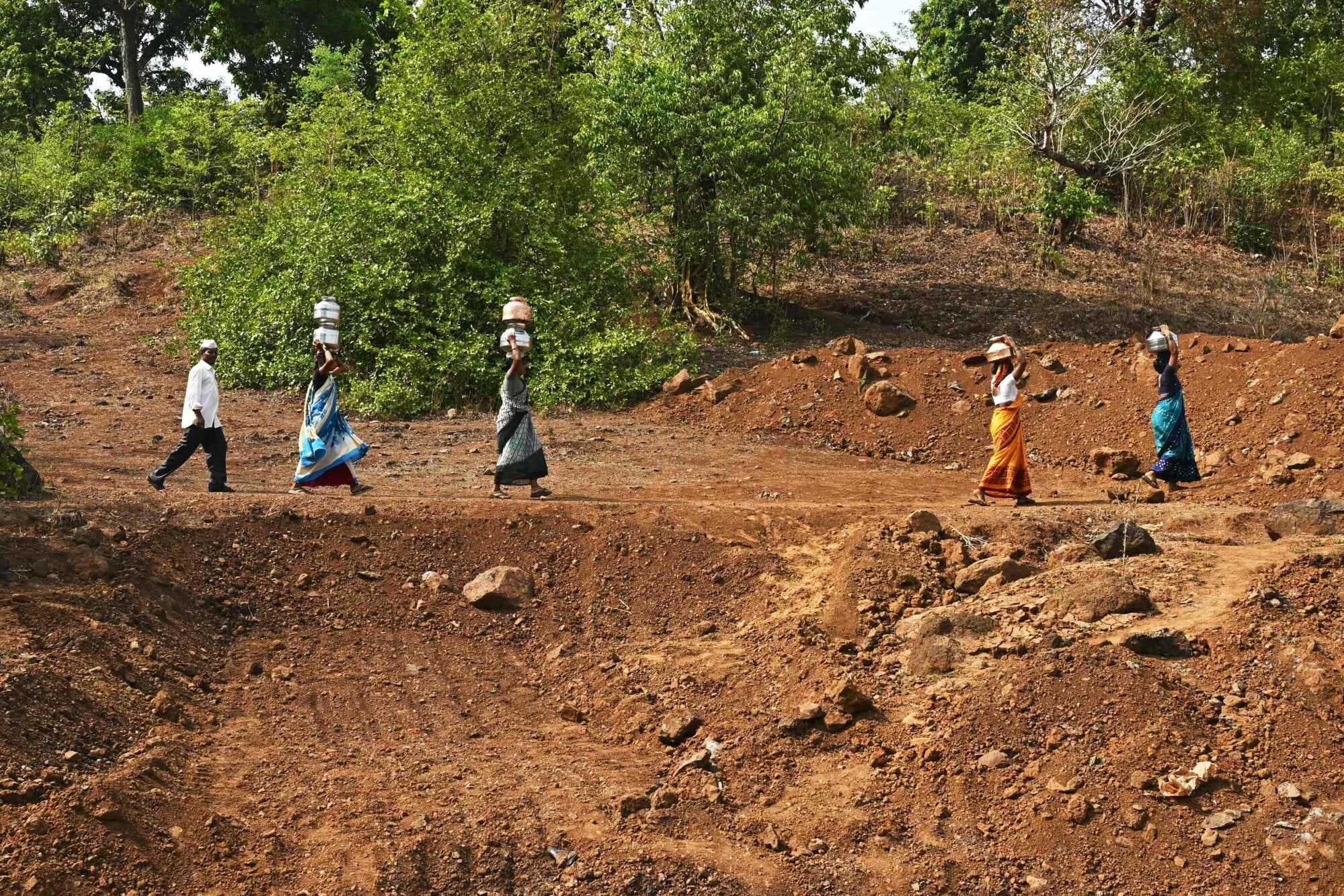 Villagers carry pots filled with water in Shahapur. Photo: AFP