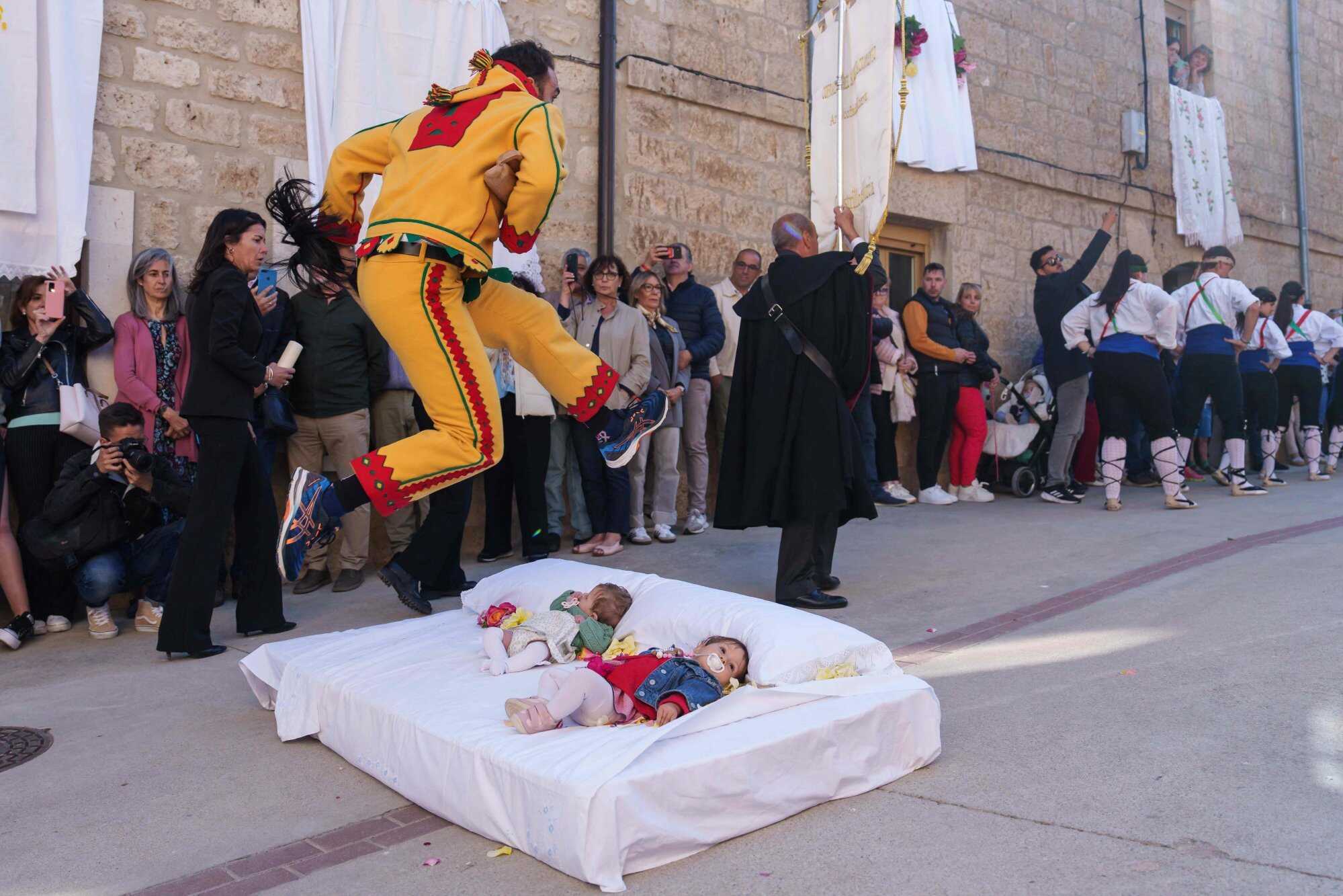 The “Colacho”, a character that represents the devil, jumps over babies lying on a mattress in the street during a festival in the Spanish village of Castrillo de Murcia. Photo: AFP