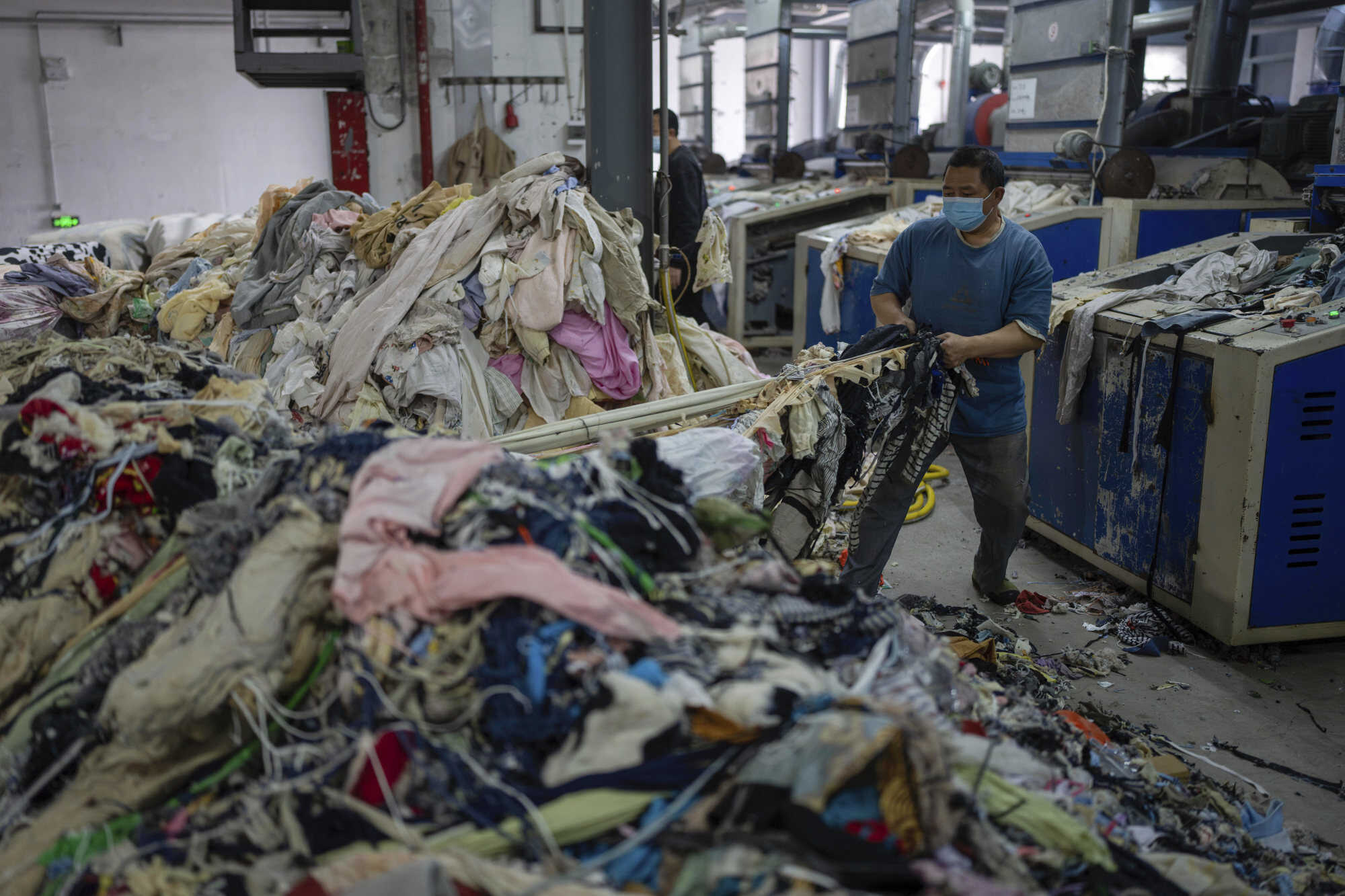 A worker feeds discarded textiles to a shredding machine at the Wenzhou Tiancheng Textile Company, one of China’s largest cotton recycling plants in eastern China’s Zhejiang province. Photo: AP