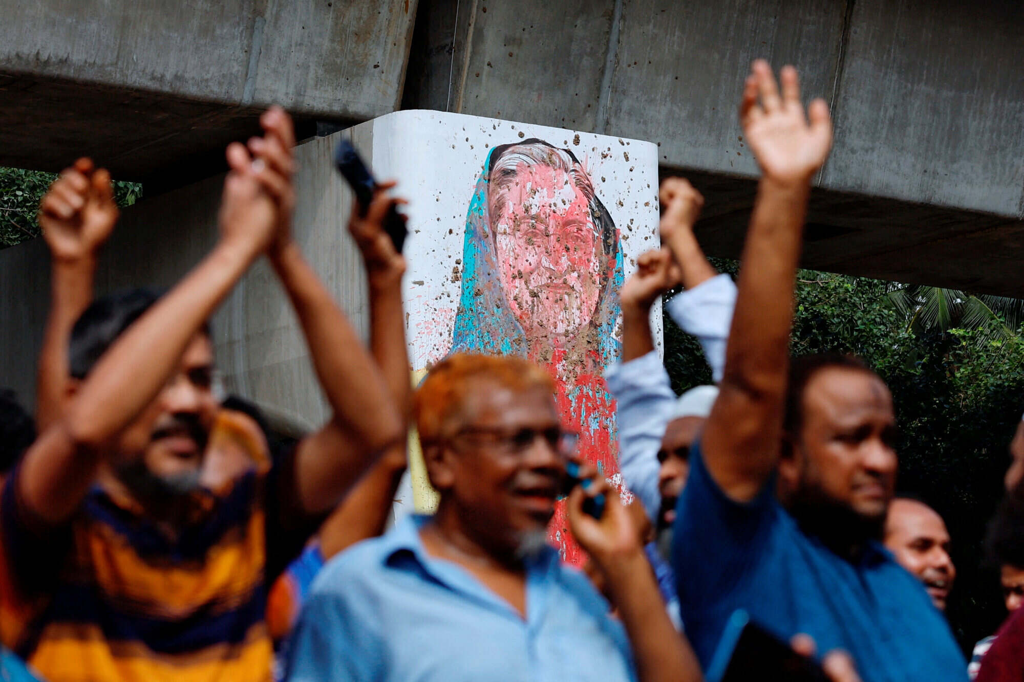 A mural of Sheikh Hasina is seen vandalised by protesters as people celebrate her resignation in Dhaka, Bangladesh. Photo: Reuters