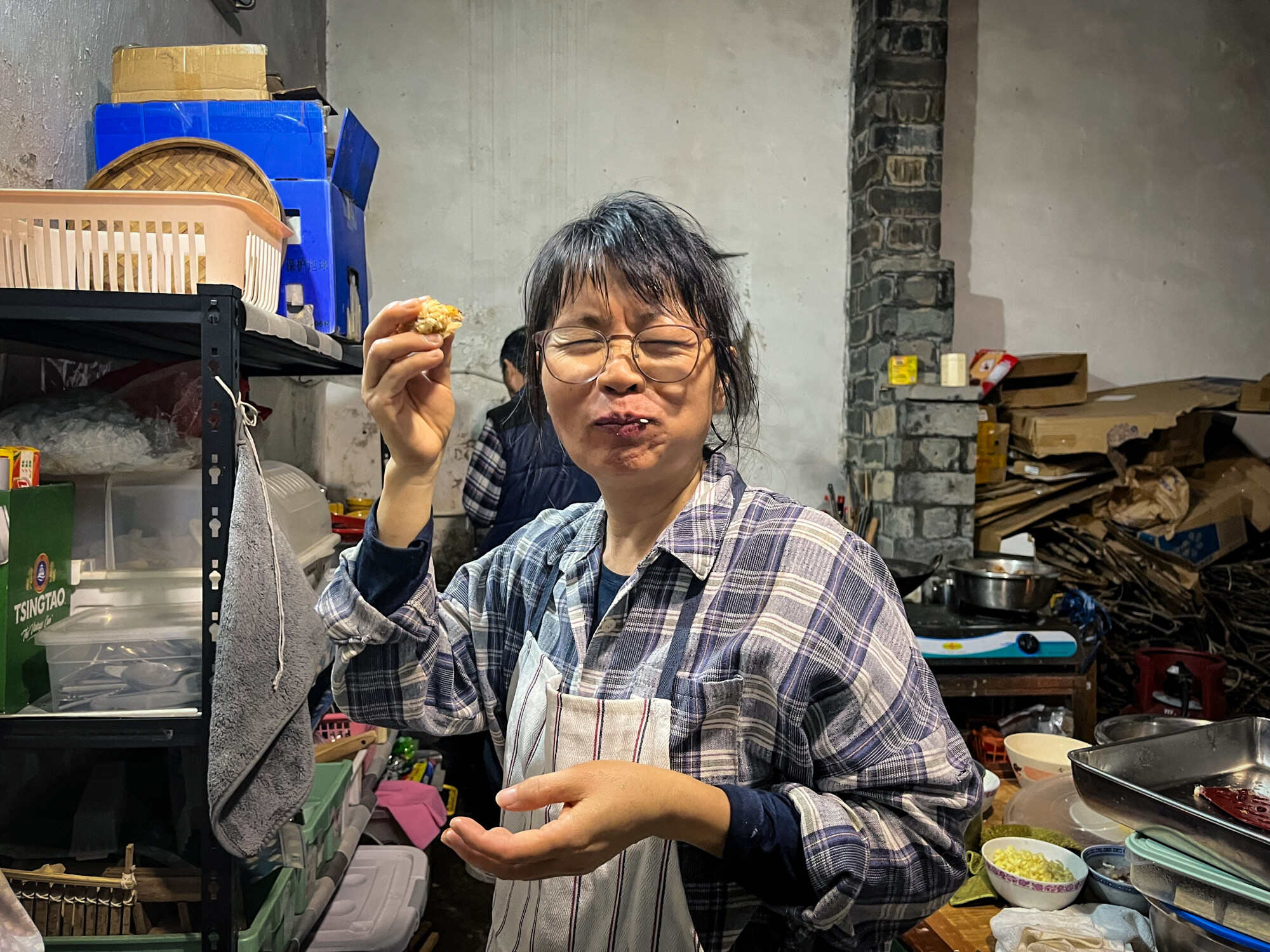 Villager Li Suet-mui tastes the glutinous rice radish cake made by actor Leung Jo-yiu. Photo: Kelly Fung