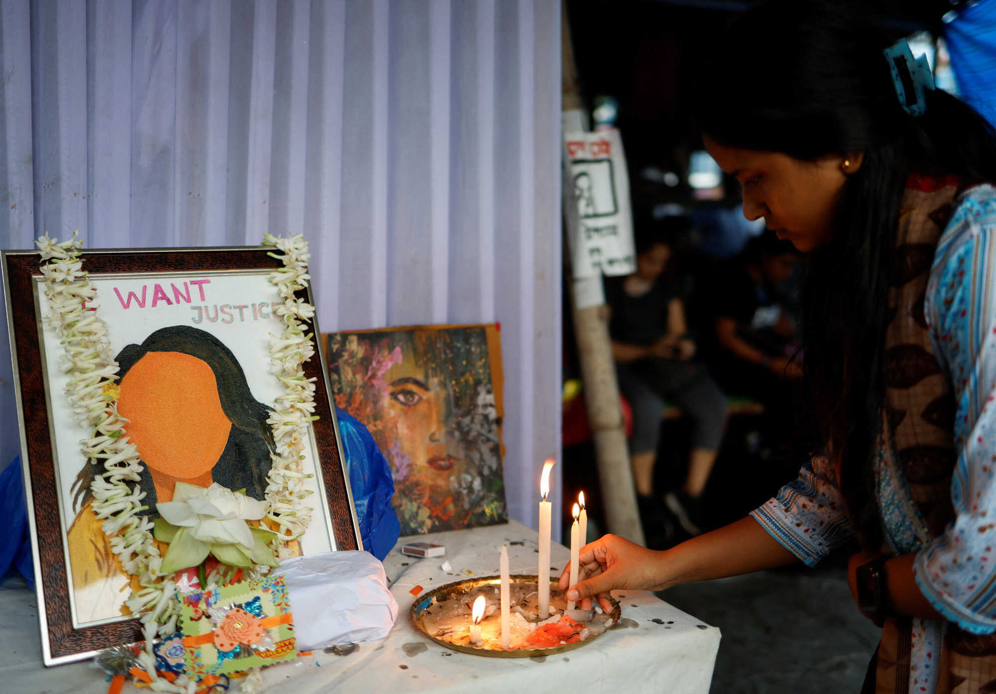 A woman lights a candle at a protest condemning the rape and murder of a trainee medic inside the premises of RG Kar Medical College and Hospital in Kolkata. Photo: Reuters