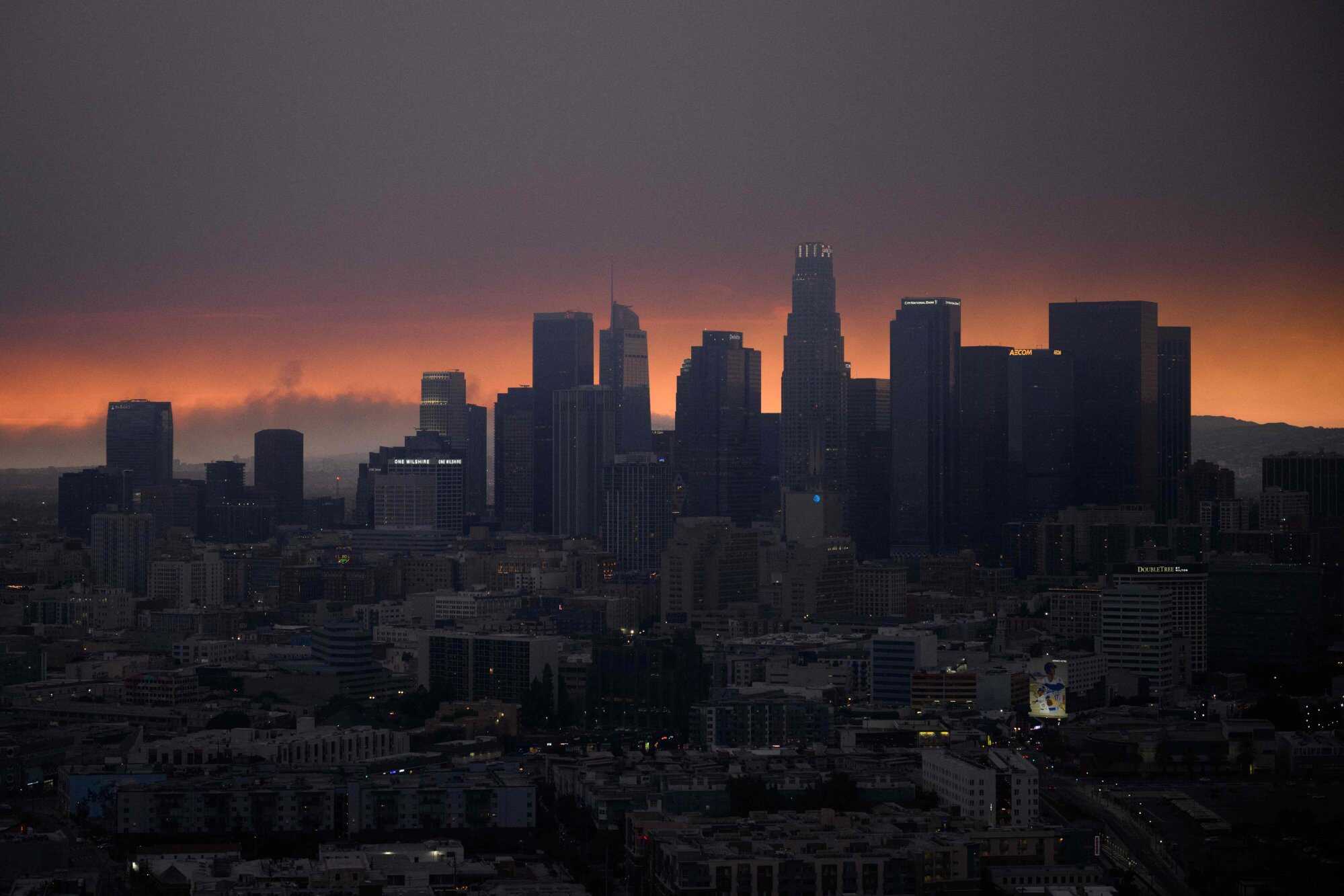 Smoke from the Palisades Fire rises behind the downtown Los Angeles skyline as the city is covered in a haze from wildfires. Photo: AFP