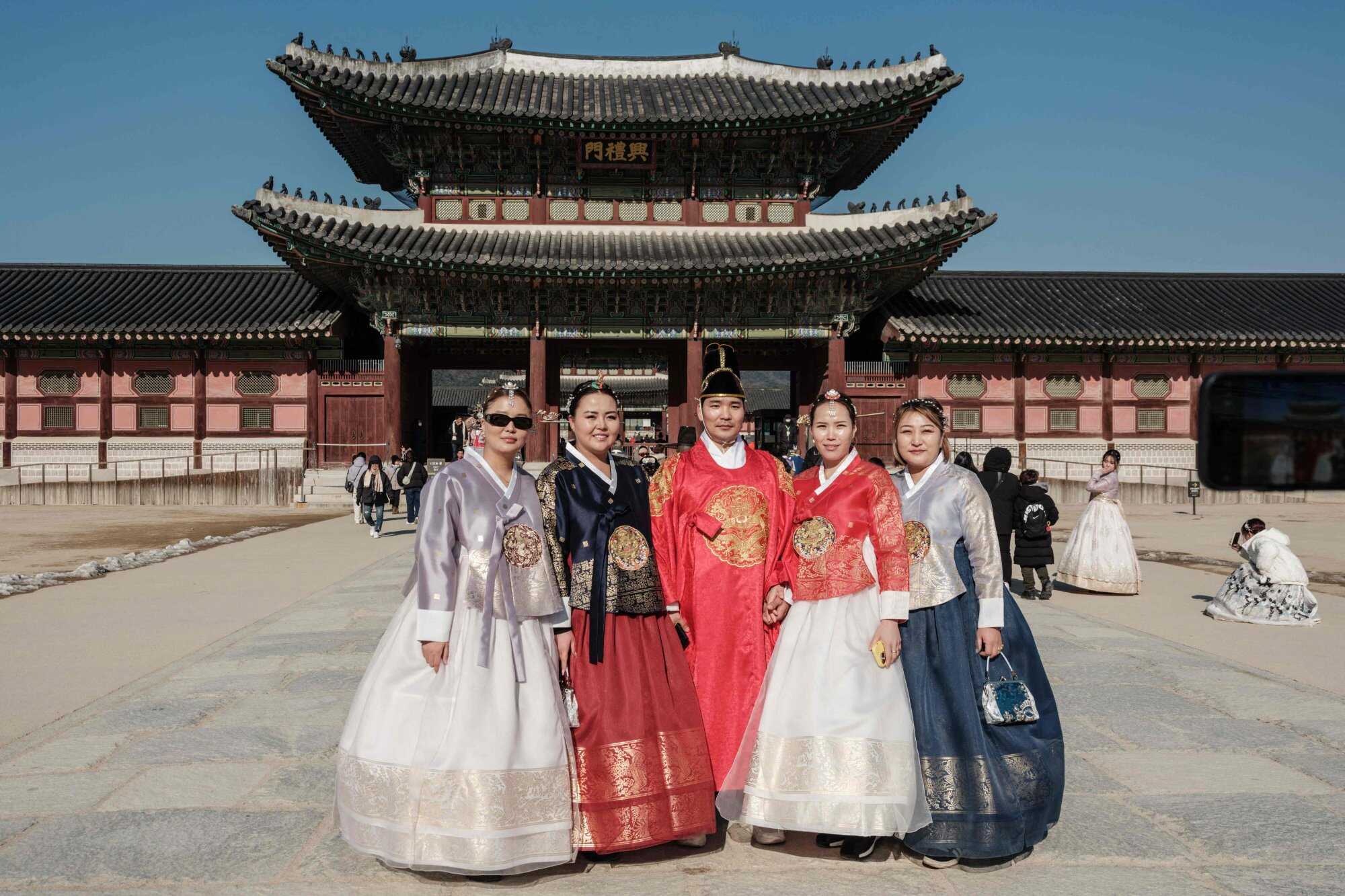 Tourists pose for photographs at Gwanghwamun Gate in Seoul, South Korea on January 11, 2025. Photo: AFP