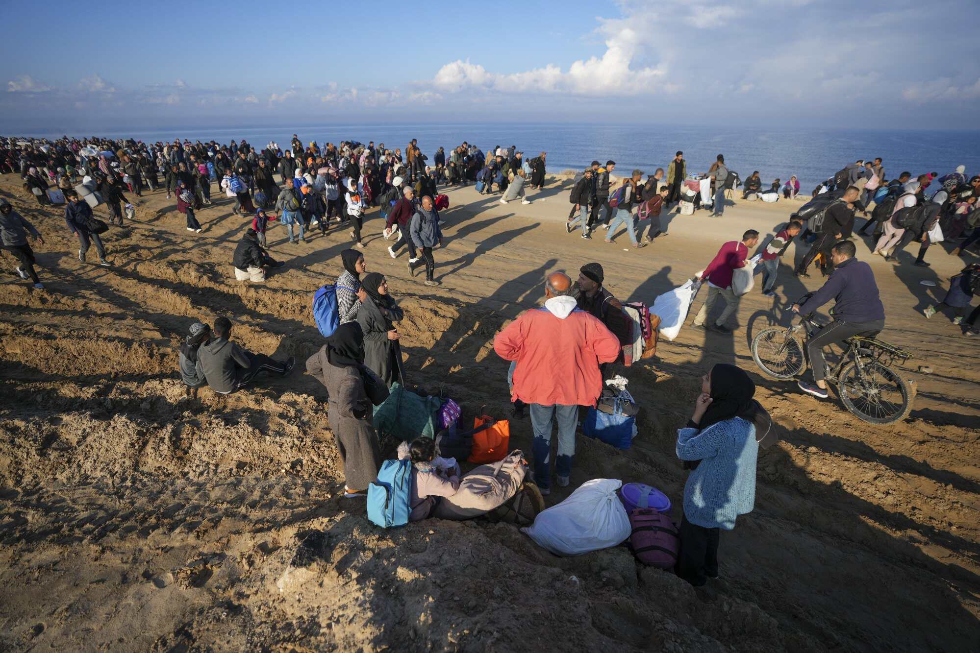 Ne’man Abu Jarad, in red jacket, and his family take a break on their journey home, on foot. Thousands of displaced Palestinians are returning home to the northern Gaza Strip, following Israel’s decision to allow them to go back for the first time since the early weeks of the 15-month war. Photo: AP