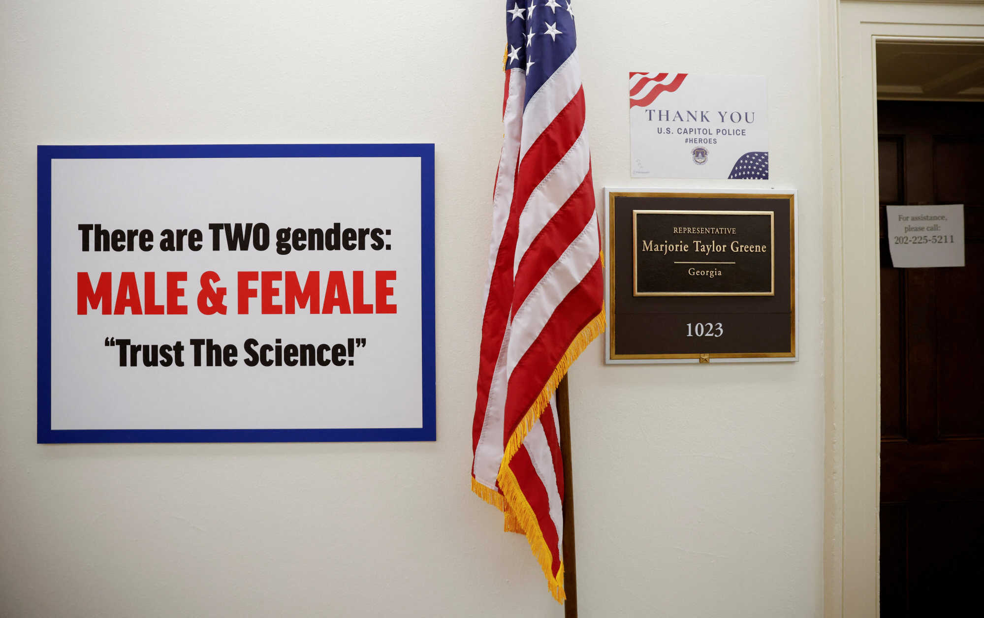 A sign hangs on the wall outside the office of United States Representative Marjorie Taylor Greene reading “There are TWO genders, MALE & FEMALE. Trust The Science!” after the Congresswoman hung it in reaction to a trans pride flag placed across the hall in 2021. Photo: Reuters