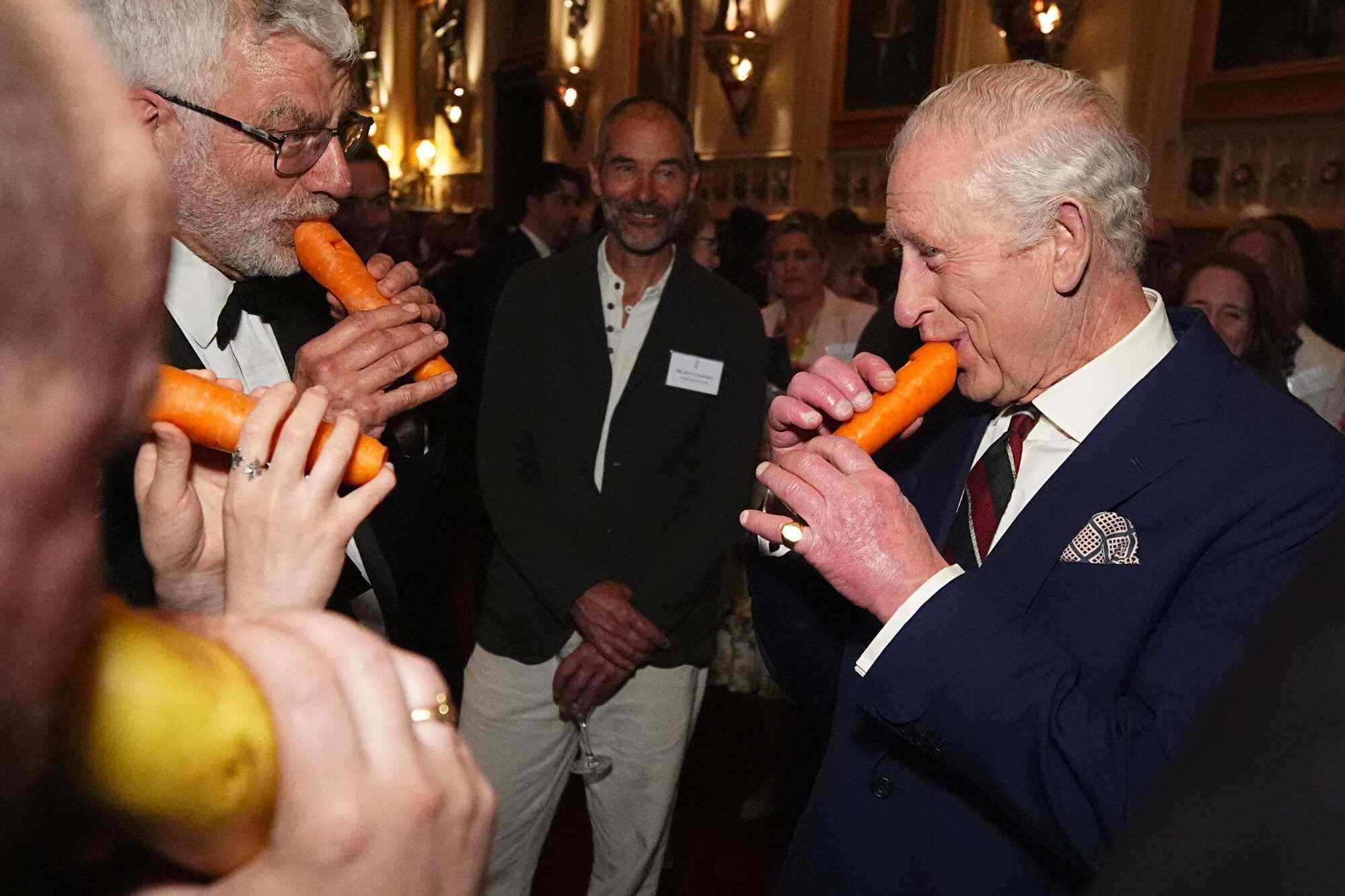 Britain’s King Charles III (right) plays a carrot with the London Vegetable Orchestra during a reception to recognise those involved in community music across the UK. Photo: AFP