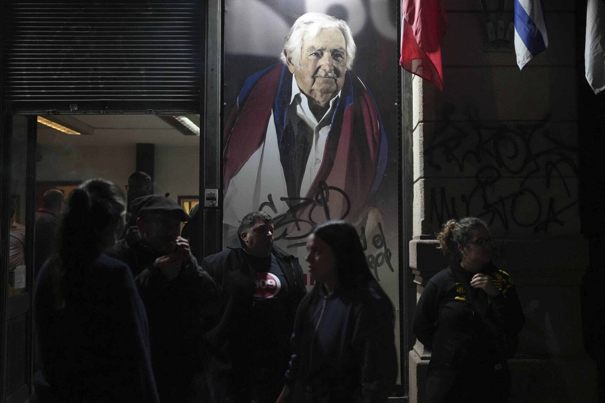 Supporters gather outside a Movimiento de Participación Popular political party headquarters, decorated with a photo of late former Uruguayan president Jose Mujica. Photo: AP