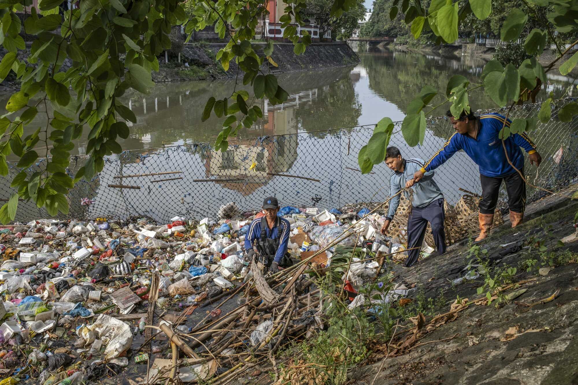 Workers clean up a river filled with trash and plastic waste in Denpasar, Bali, Indonesia. Photo: EPA-EFE