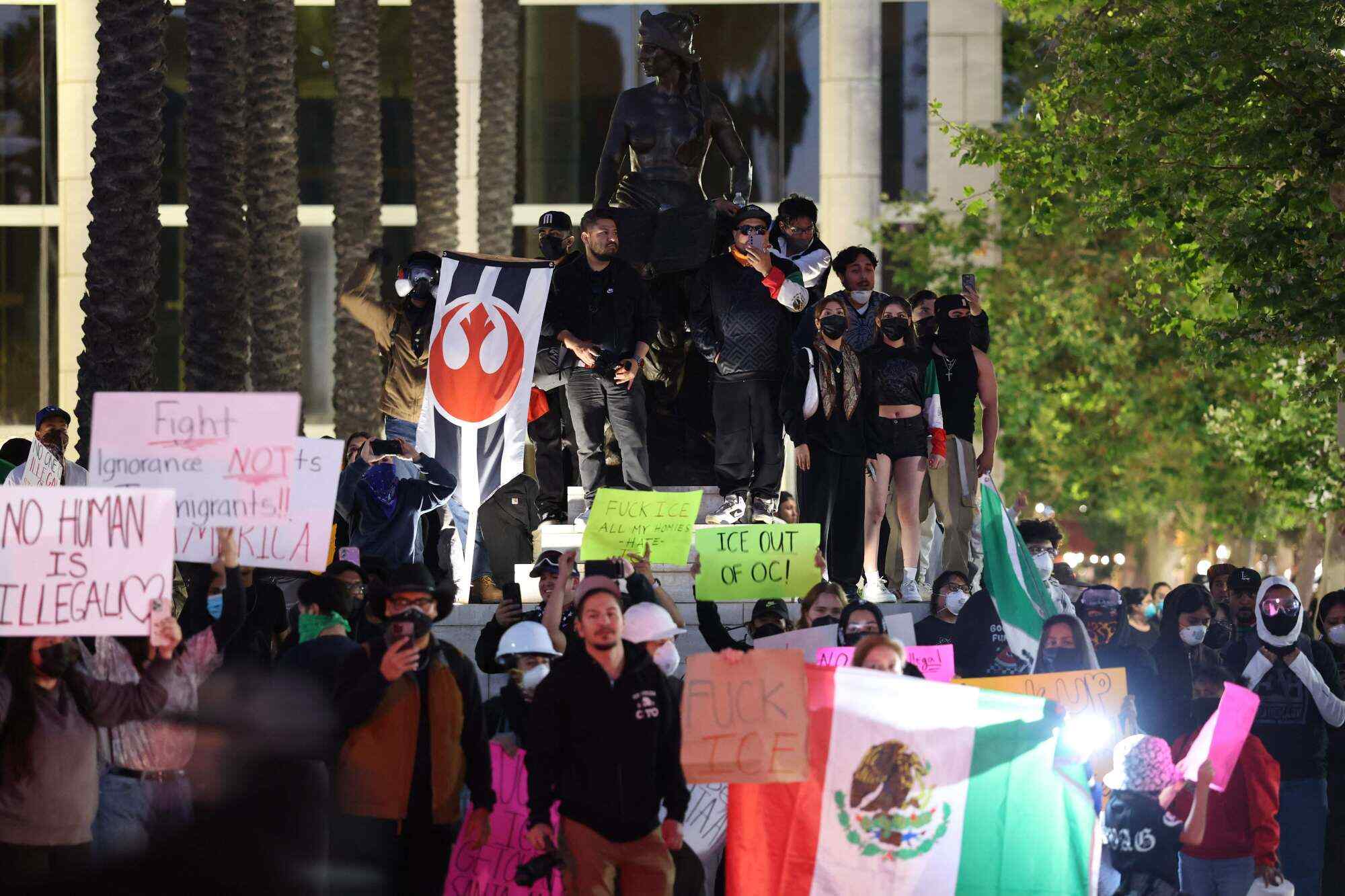 Protesters gather with signs and flags near a federal building in Santa Ana, California, following reports of Immigration and Customs Enforcement (ICE) raids on June 9, 2025. Photo: AFP